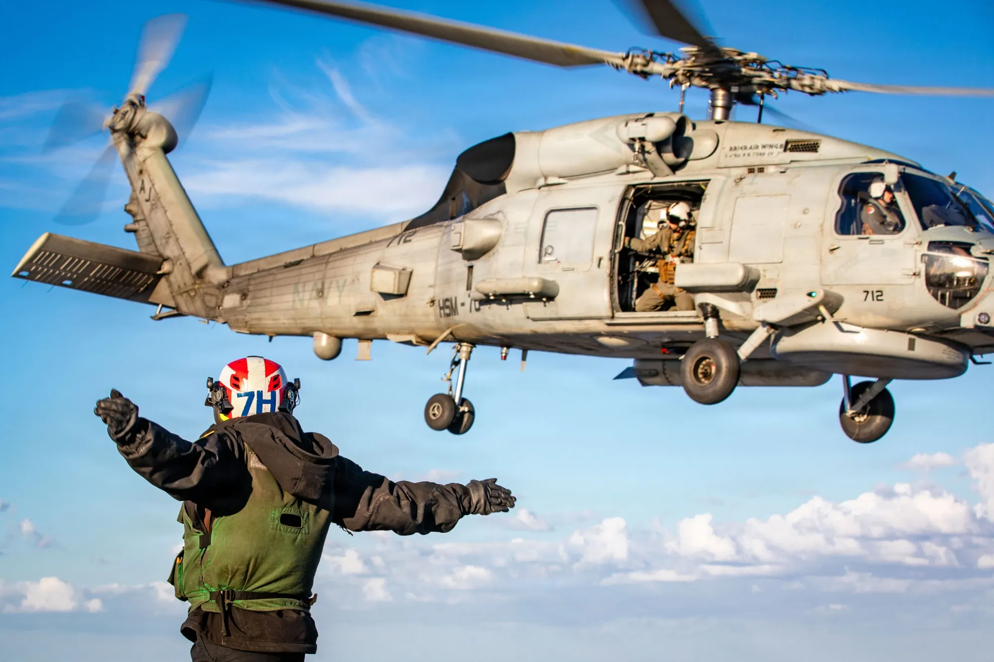 A U.S. Sailor signals the launch of a Sea Hawk helicopter, on the flight deck of USS Gerald R. Ford, while supporting Operation Epic Fury on Feb. 2.