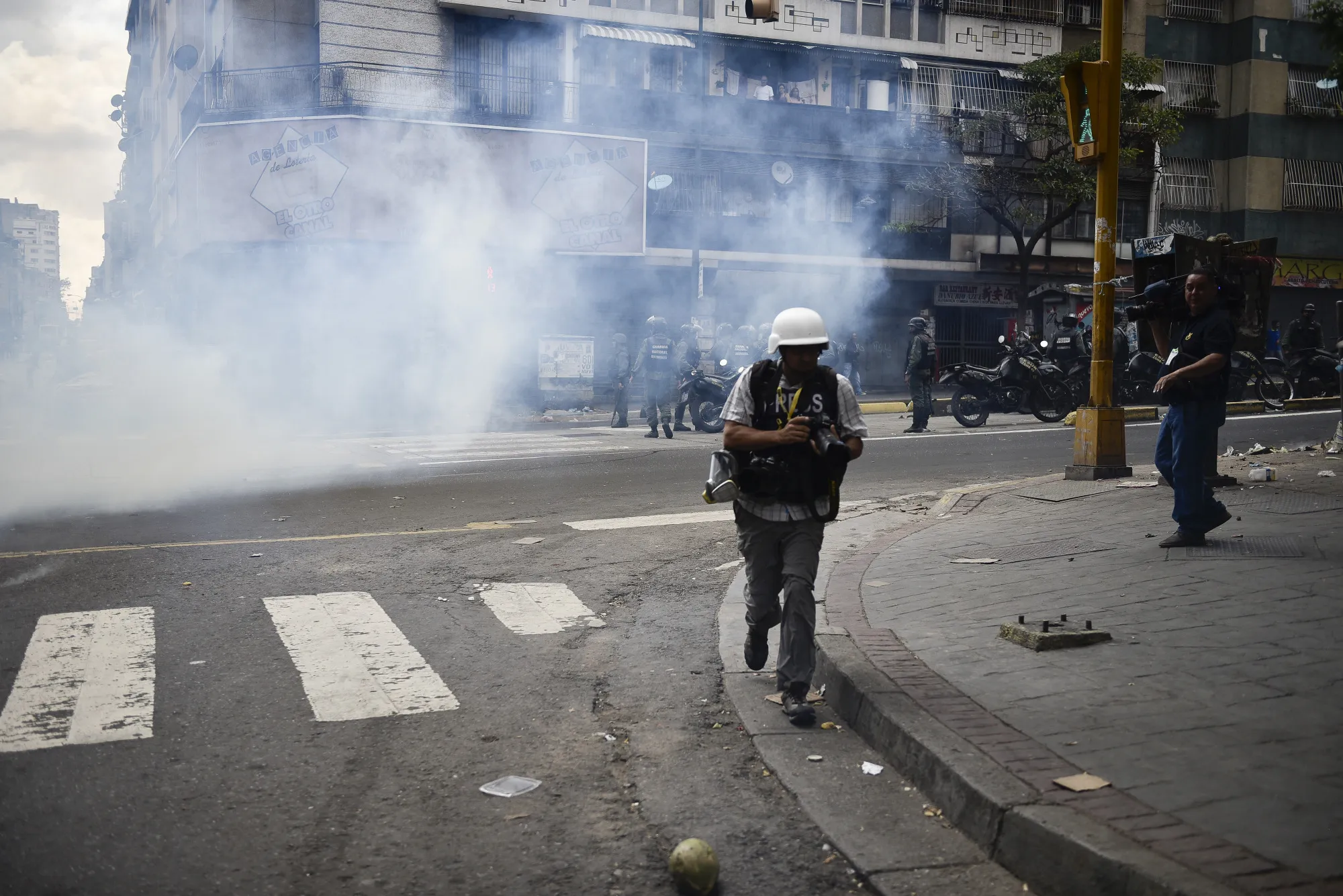 A photographer moves to safety during a demonstration in Caracas on Thursday.
