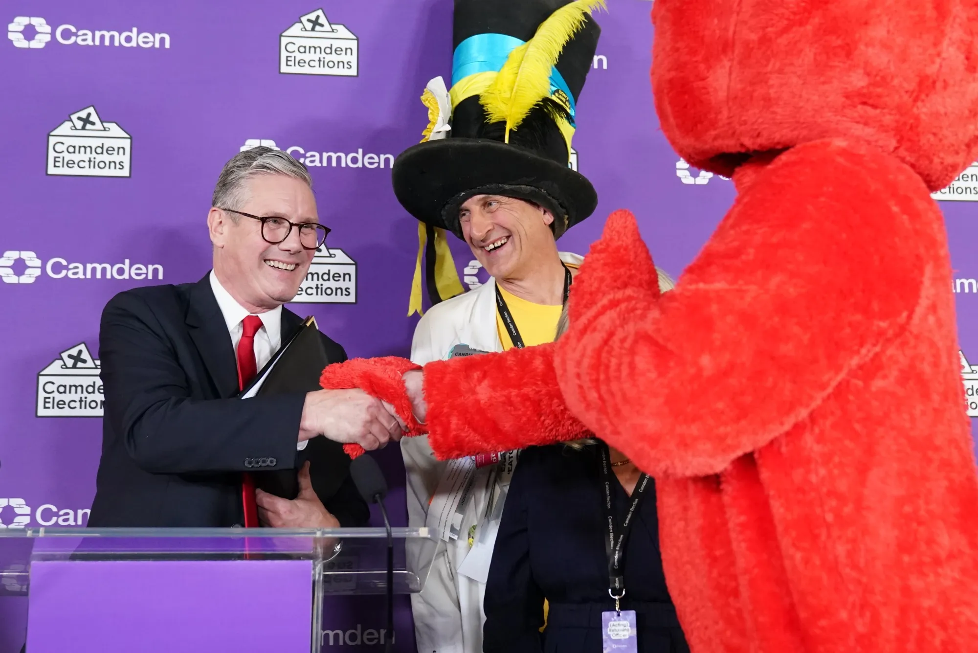 Keir Starmer shakes hands with fellow candidates — including one dressed as Elmo — after he was declared winner of the Holborn and St Pancras constituency where he stood for reelection.
