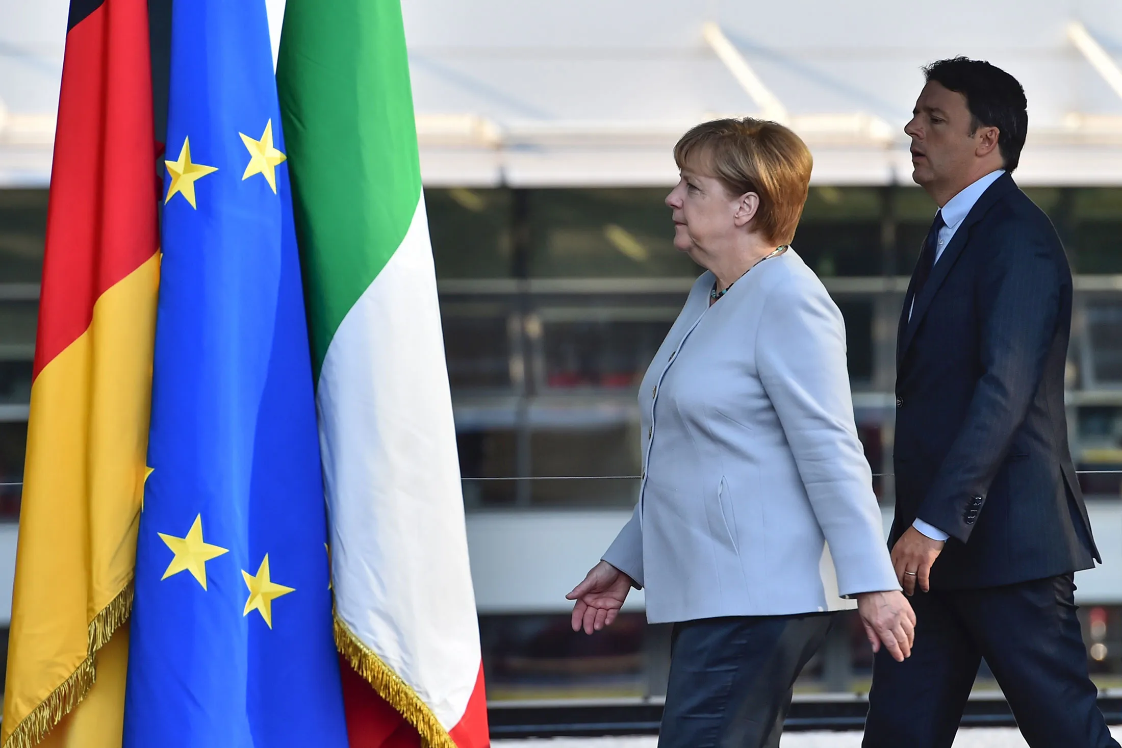 Italian Prime Minister Matteo Renzi, right, and German Chancellor Angela Merkel, left, arrive for a joint press conference during a bilateral meeting at the Ferrari farm in Maranello on August 31, 2016.
