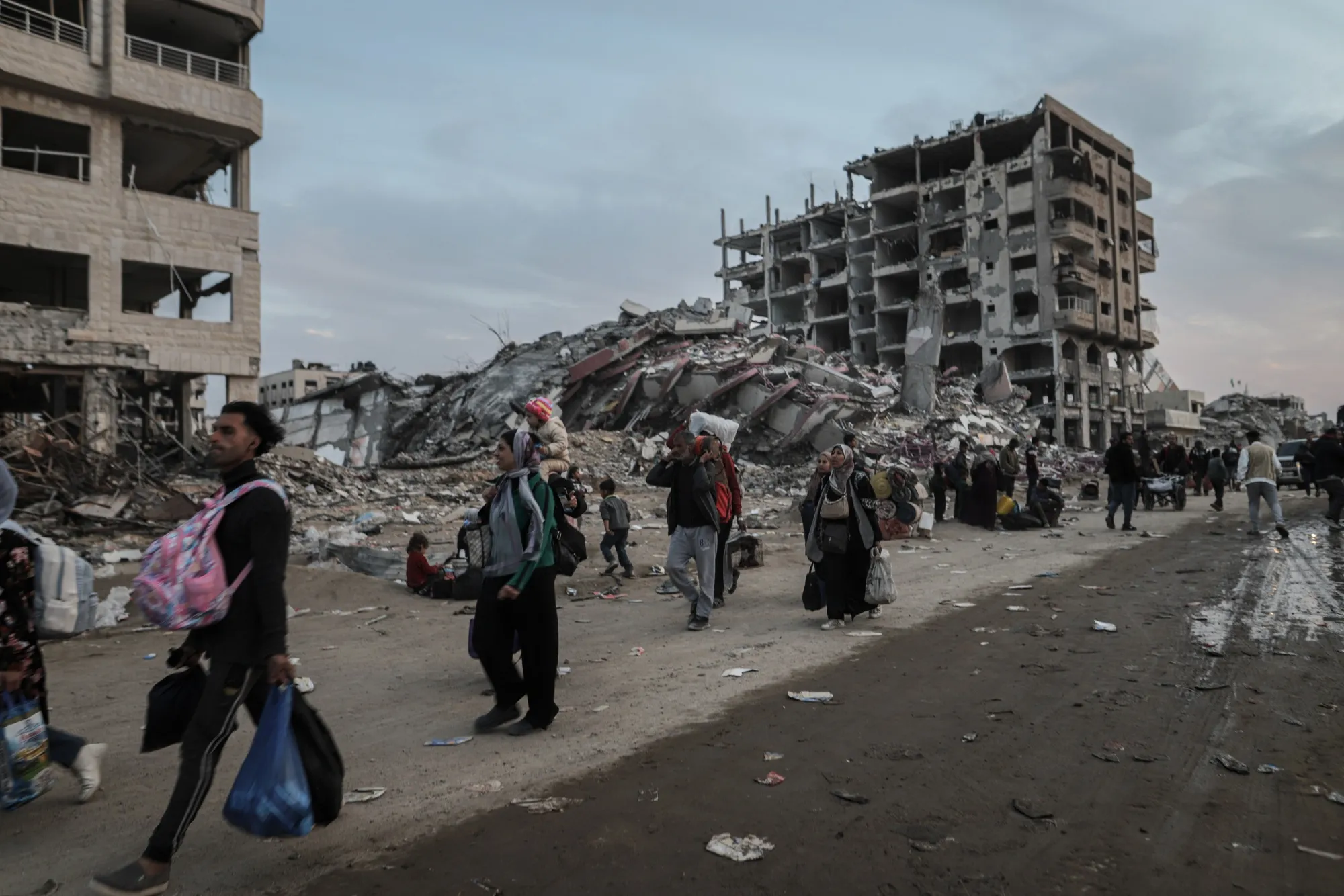 Displaced Palestinians walk past destroyed buildings as they return to northern Gaza, on Jan. 28.