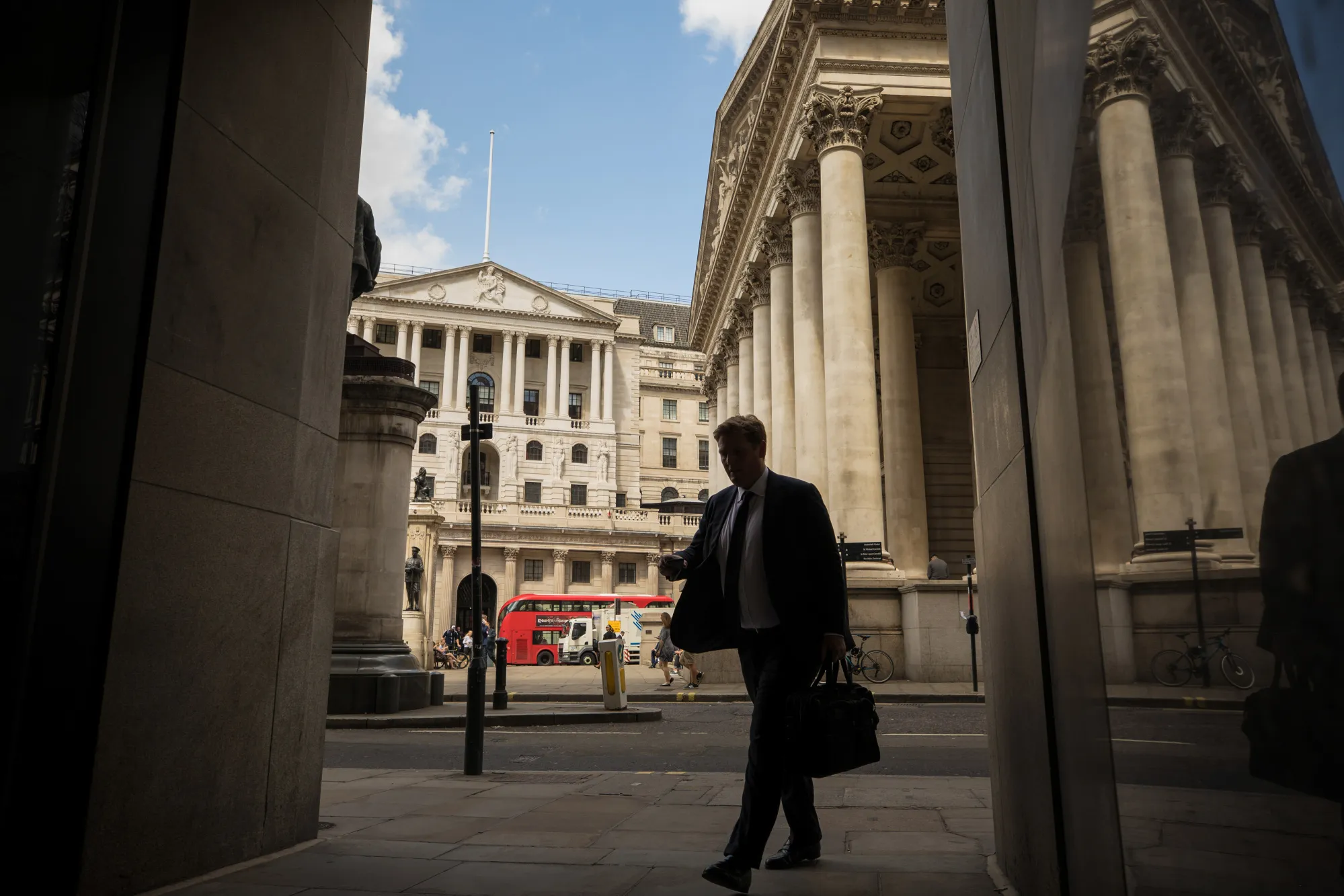 A city worker walks in view of the Bank of England in London.