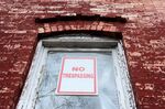 Toxic lead paint peels from a window frame on a rowhouse in Baltimore, Maryland.