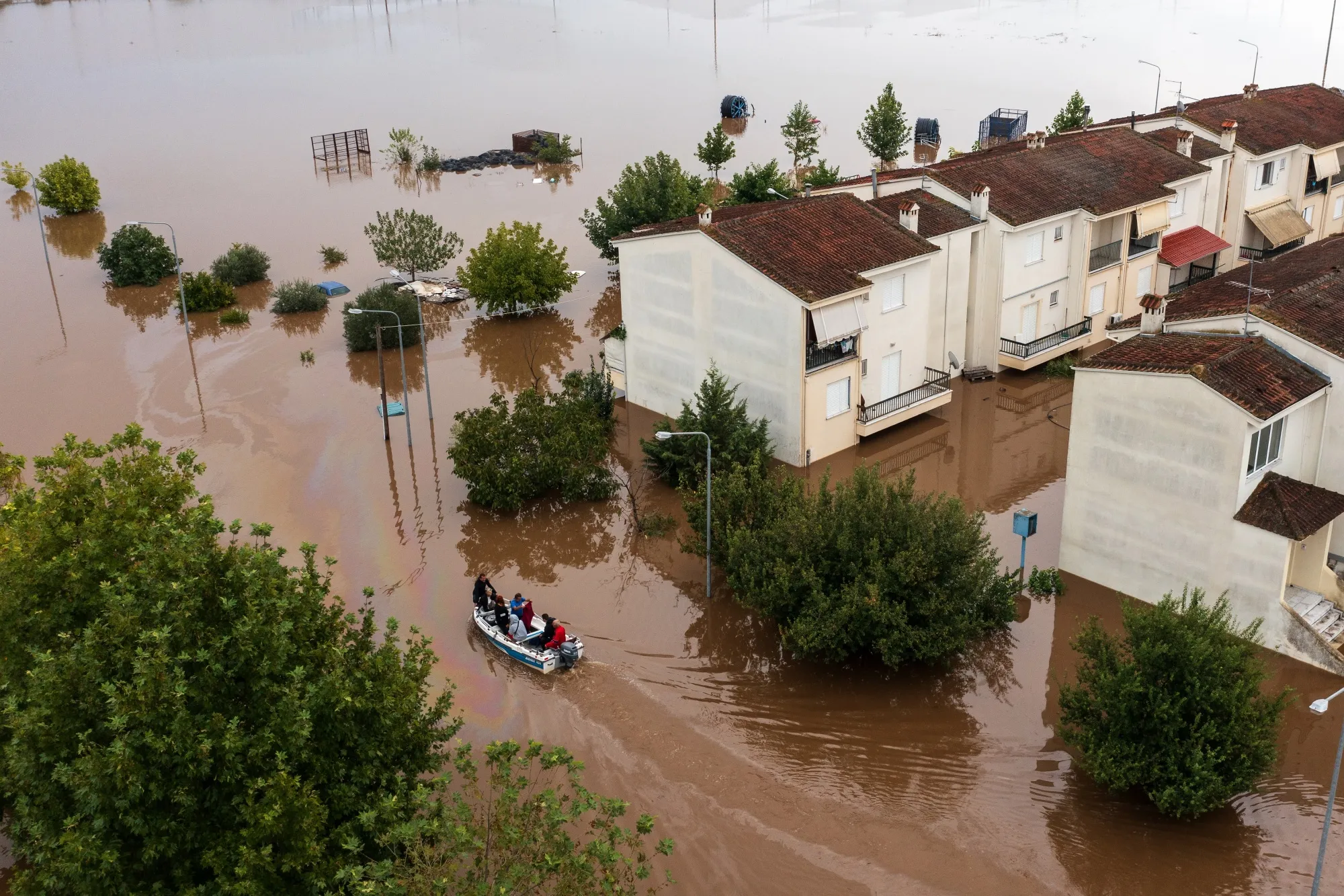 People on a boat help residents move through floodwater following heavy rains caused by Storm Daniel in Greece.