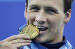 Ryan Lochte, of the United States, bites his gold medal for the men's 200 meters freestyle at the FINA Swimming World Championships in Shanghai, China, on July 26, 2011. Ryan Lochte told The Associated Press by phone Sunday, July 3, 2022, that he is auctioning off all of his Olympic silver and bronze medals, with the proceeds going to a charity benefitting children. The 37-year-old swimmer earned 12 medals over four Olympics, including six gold that he plans to keep for now. (AP Photo/Michael Sohn, File)