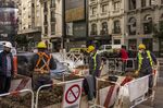 Workers wearing protective masks work on the street in the Recoleta neighborhood of Buenos Aires, Argentina, on&nbsp;May 14,.