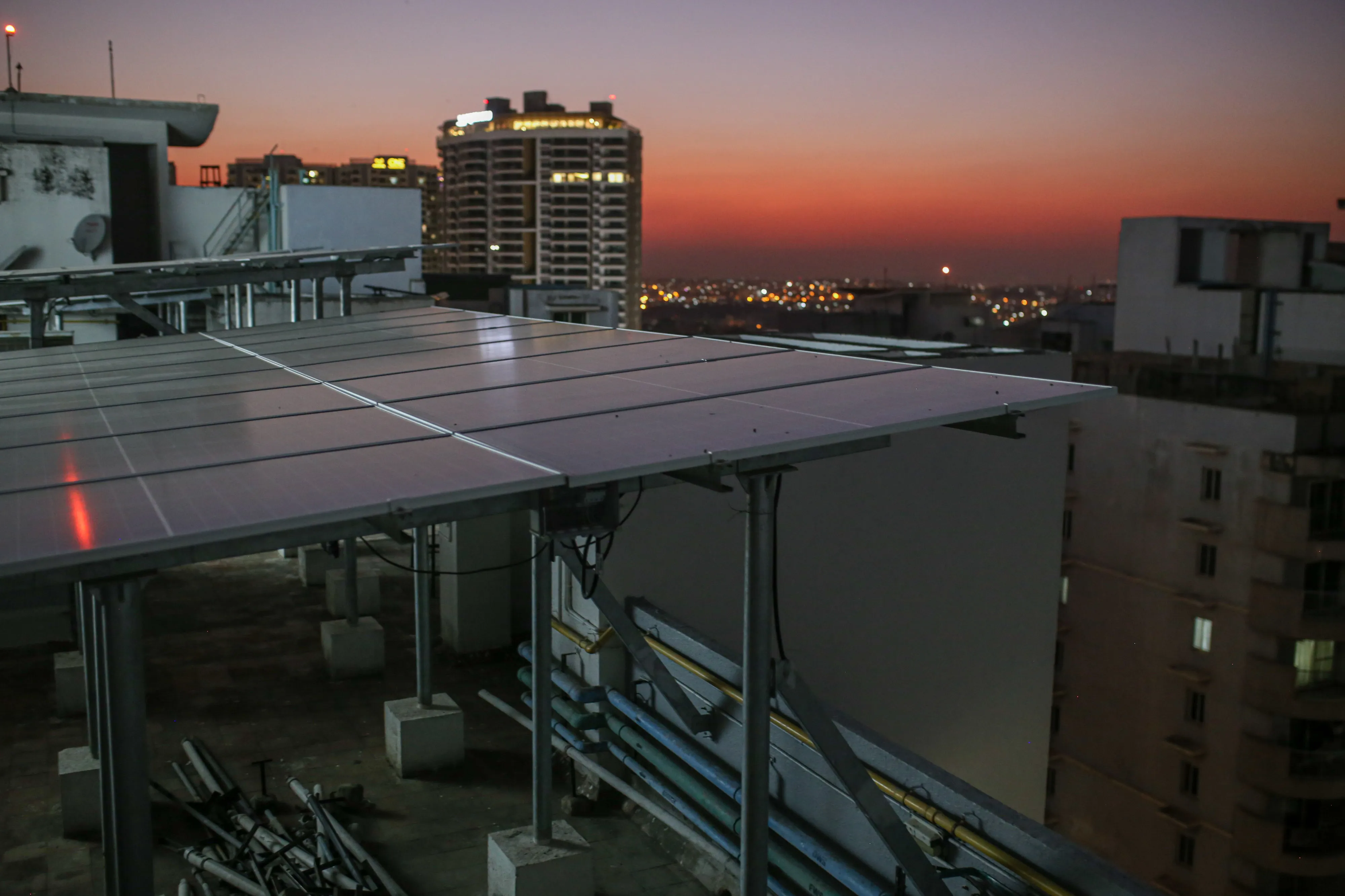 Solar panels on the roof of an apartment block at dusk in Bengaluru, India.
