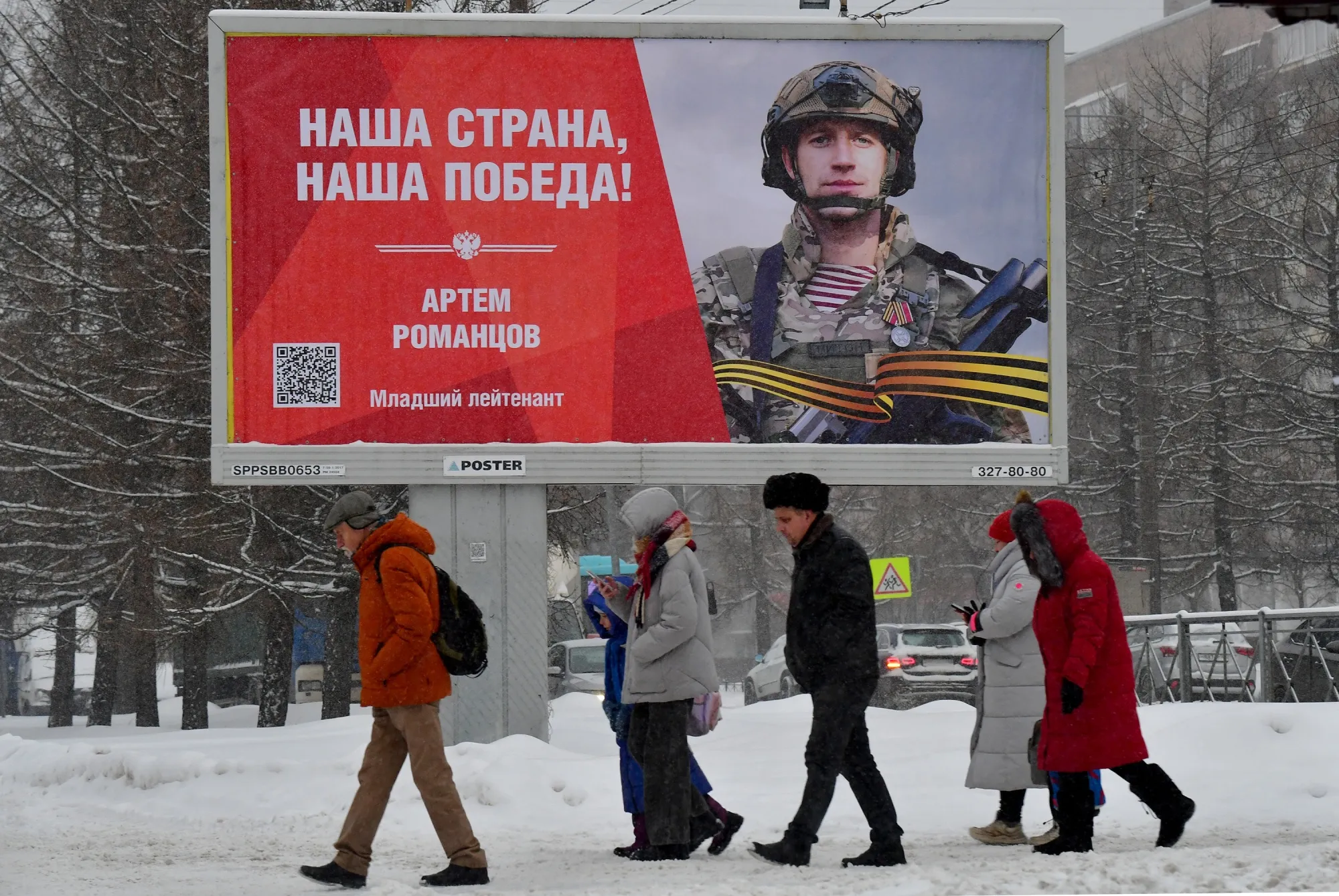 People walk past a billboard&nbsp;reading "Our country, our victory!" in Saint Petersburg, on Jan. 16.