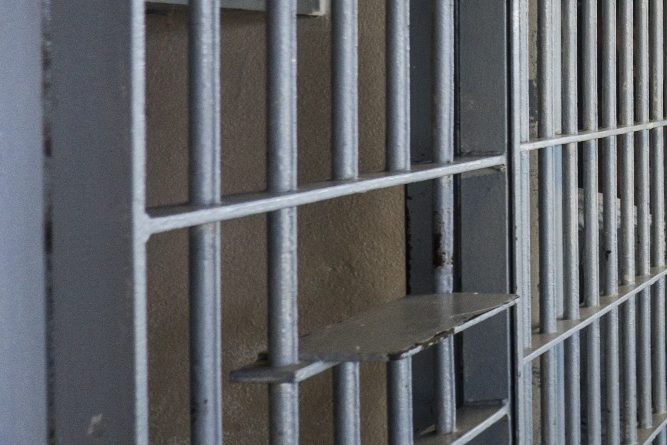 Empty prison jail cell bars.