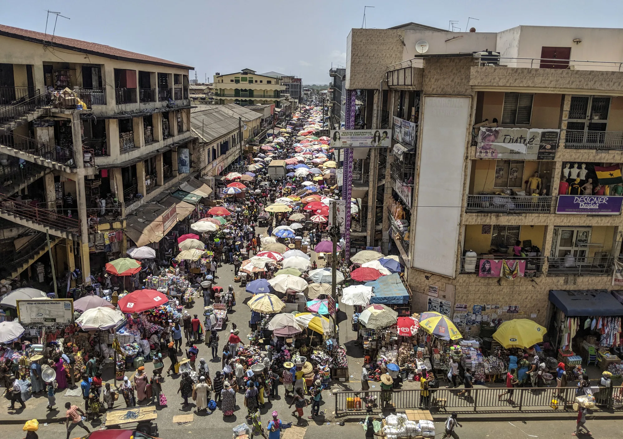Pedestrians pass by stalls at Makola market in Accra, Ghana, on Thursday, March 15, 2018.&nbsp;