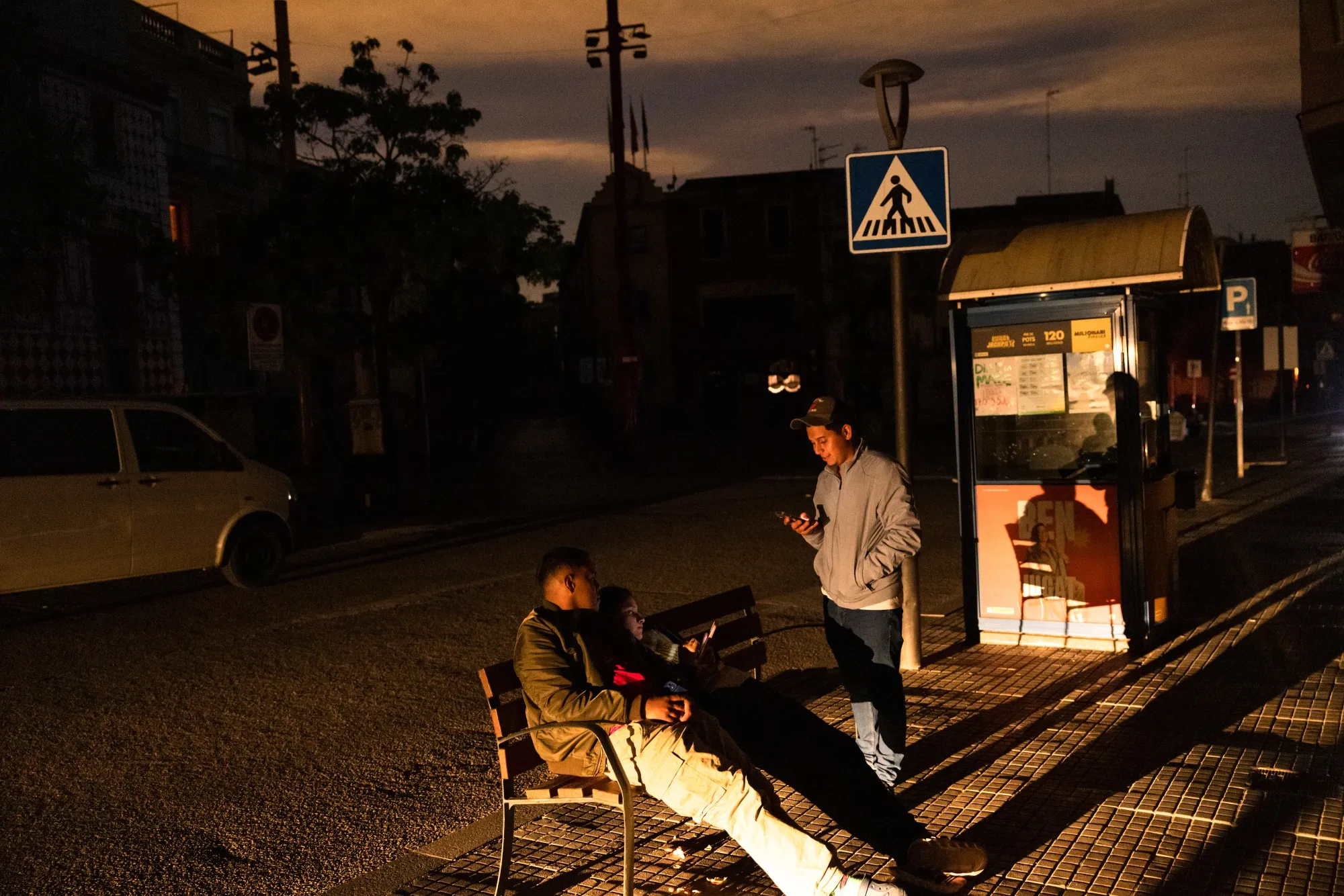 Pedestrians try to use their mobile phones on an unlit street during a power outage in Molins de Rei on April 28.