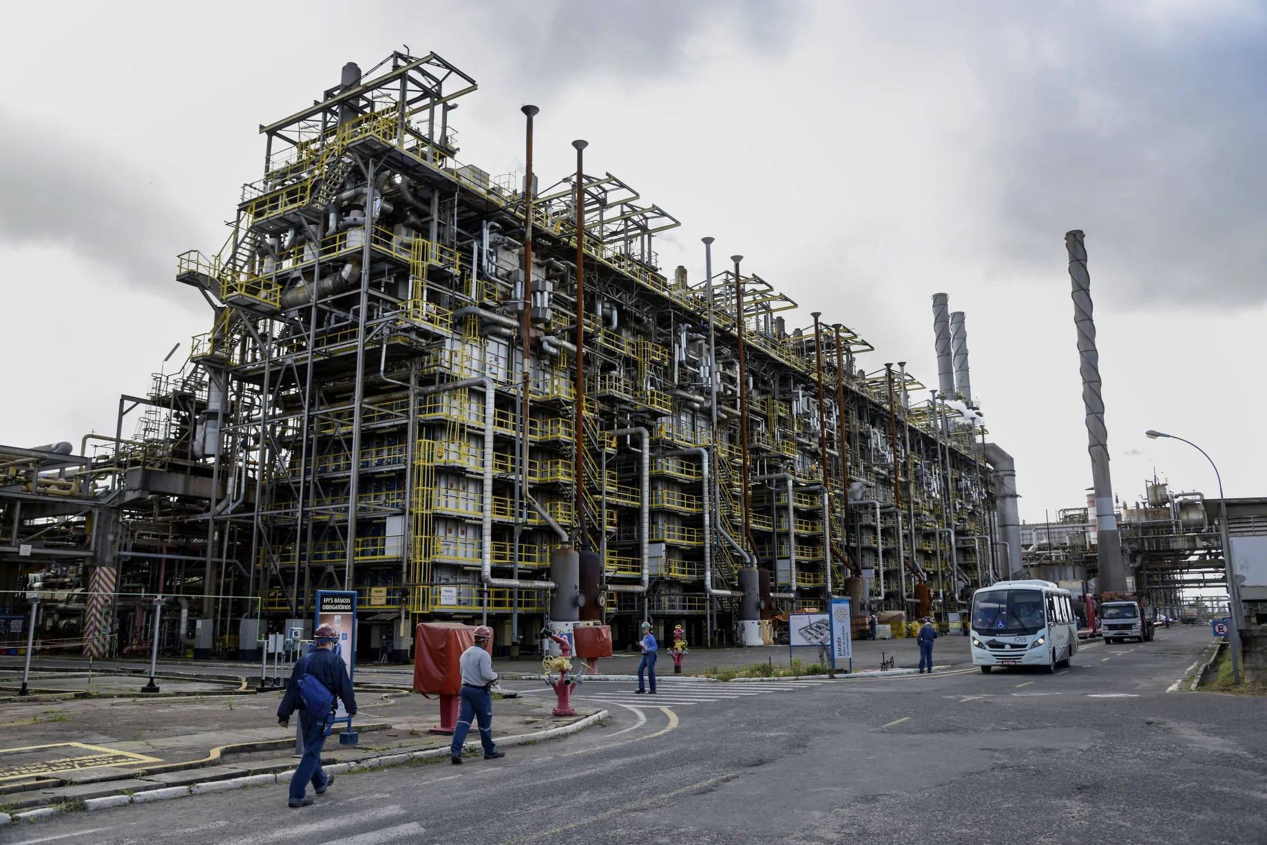 Workers walk past a naphtha production area at a&nbsp;petrochemical plant in Camacari, Brazil.