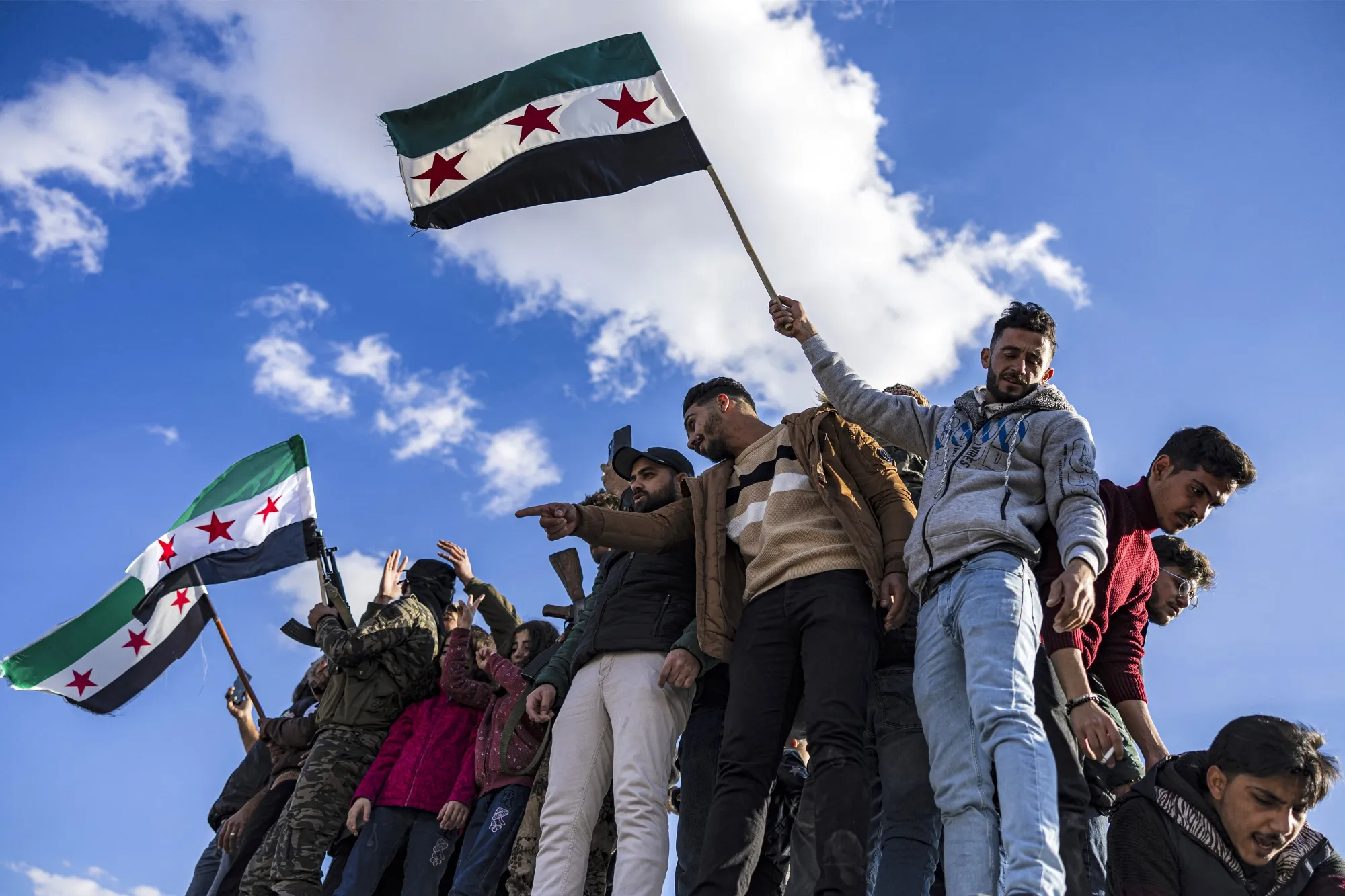 People gather with independence-era Syrian flags to celebrate the ouster of Syria's president Bashar al-Assad in Damascus on Dec. 13.