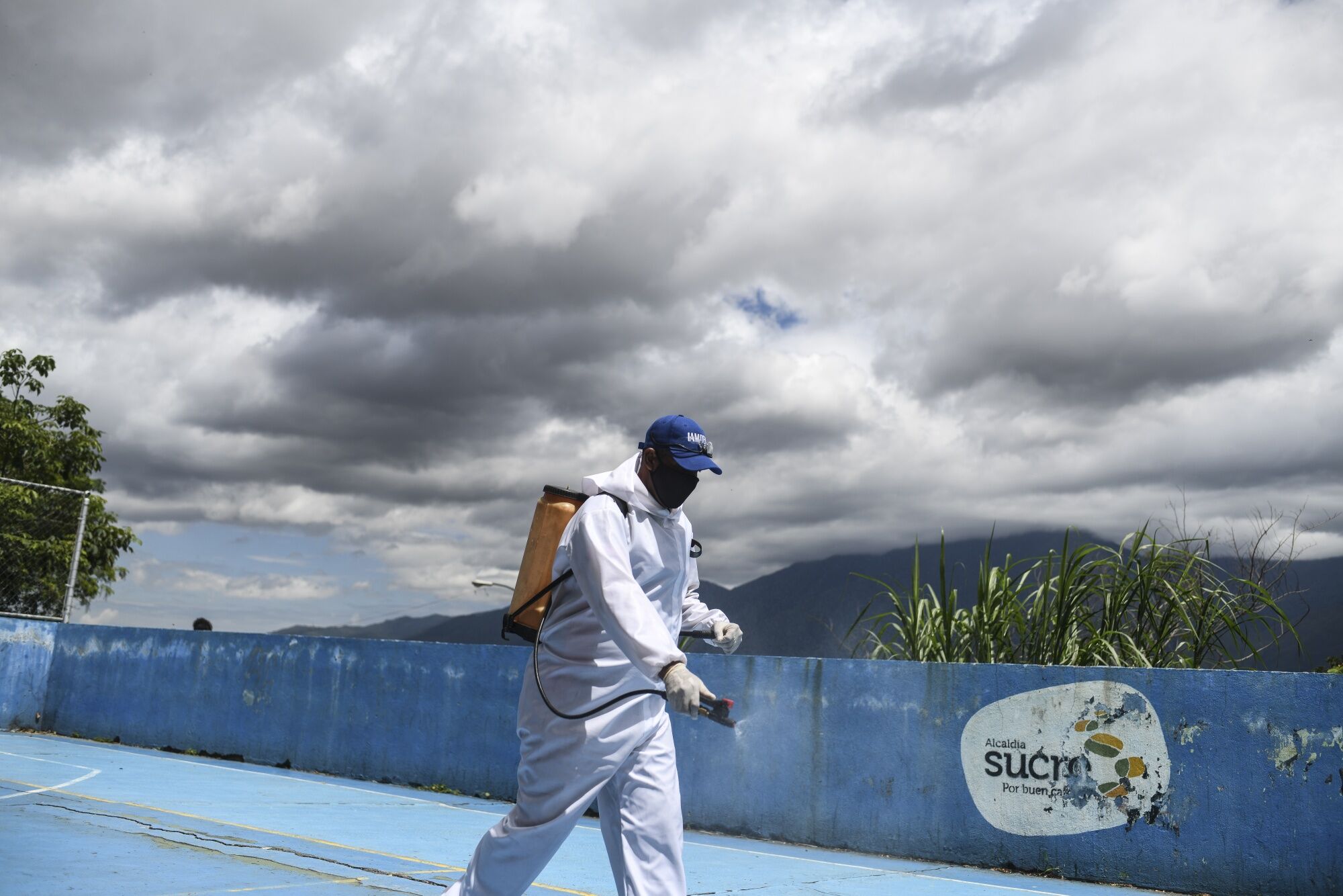 A city crew member disinfects a sports court in the Petare neighborhood of Caracas, Venezuela, on Thursday, Sept. 3, 2020.