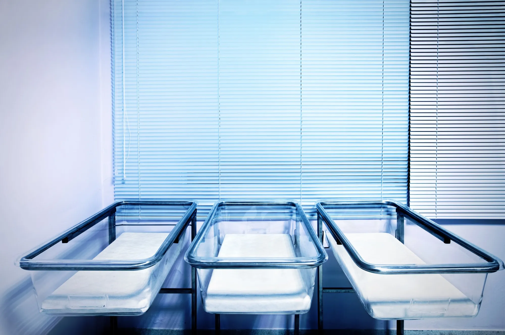 Baby cribs at a maternity ward. Low birth rate and fertility concept.