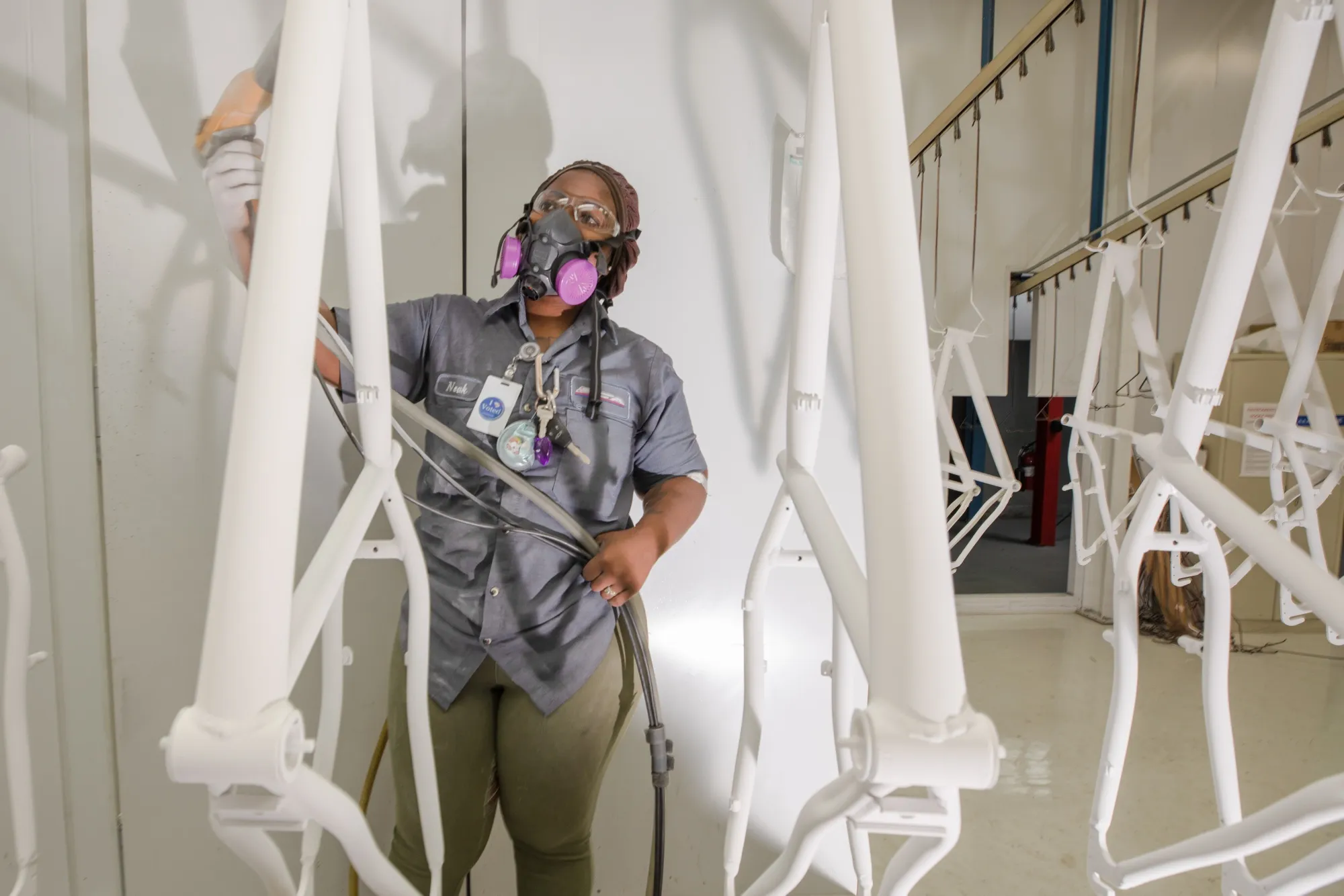 A worker coats bicycle frames with powder paint at a production facility in Manning, South Carolina.