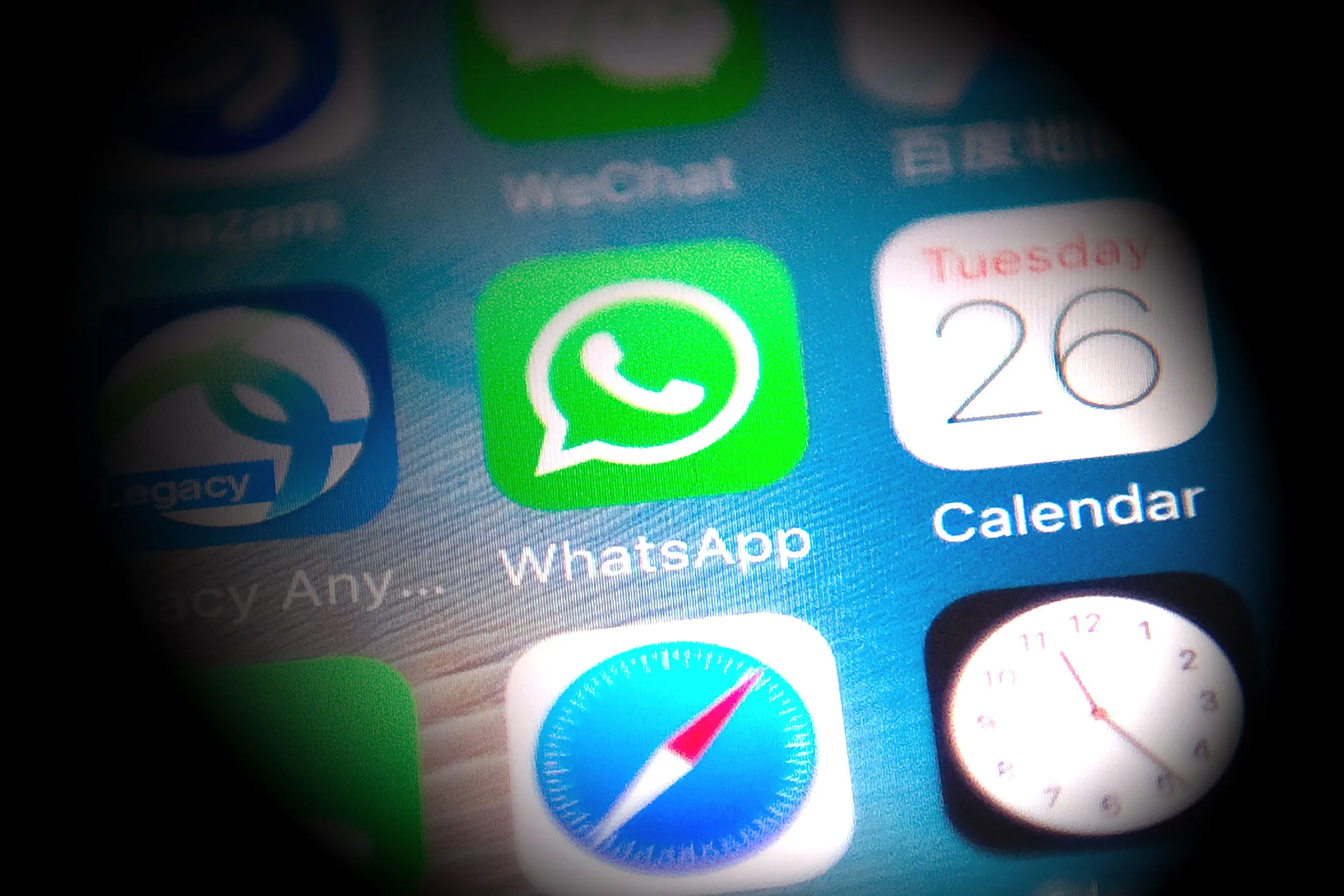 This photo illustration shows the Whatsapp application logo (C) on a smartphone screen in Beijing.