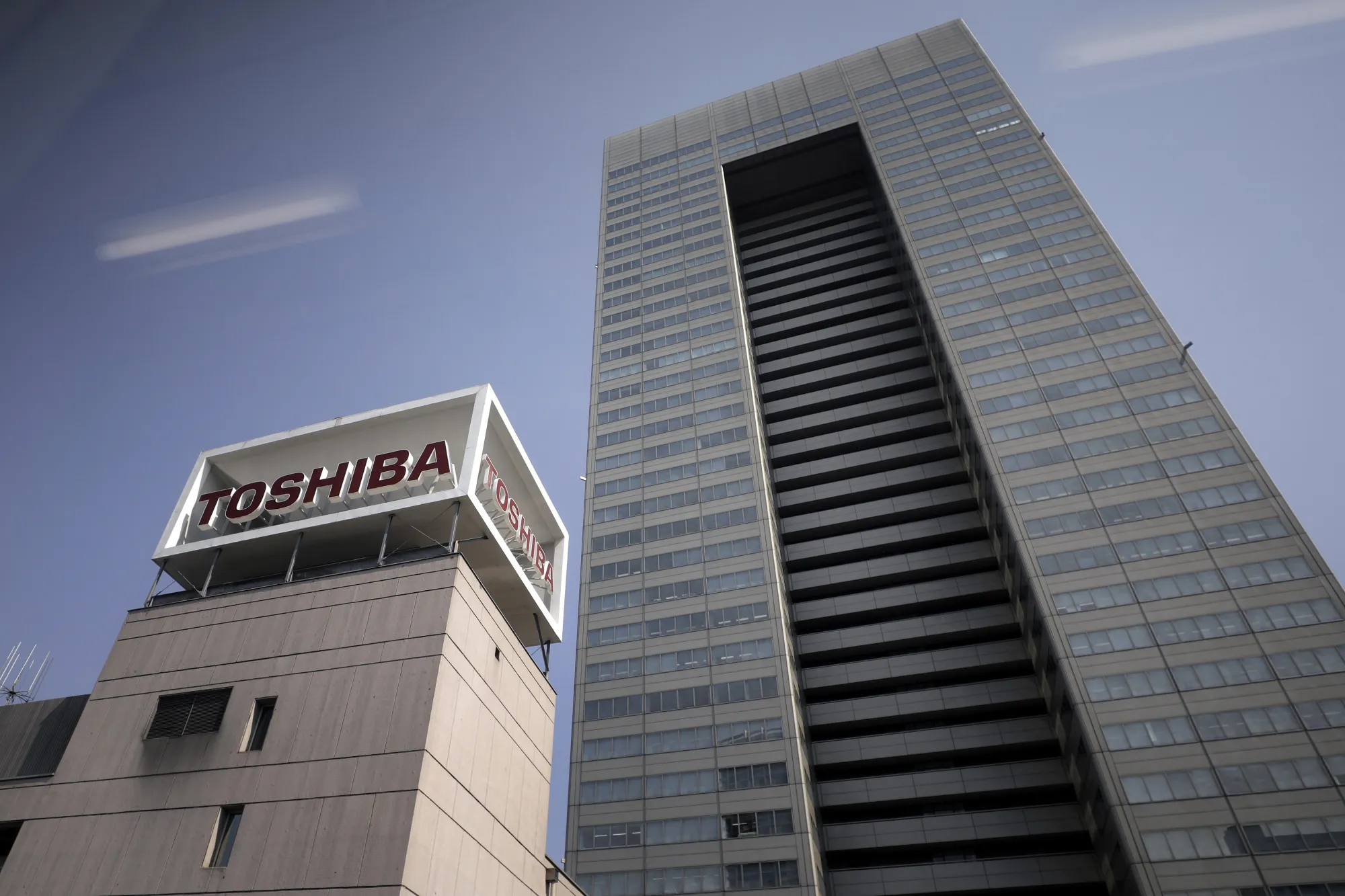 Signage for Toshiba Corp. displayed atop the company's headquarters is seen through a monorail train window in Tokyo, Japan, on Tuesday, March 28, 2017. Toshiba Corp. projected its annual loss could more than double to a record 1.01 trillion yen ($9.1 billion) as its U.S. nuclear unitWestinghouse Electric filed for Chapter 11 bankruptcy in New York court.