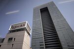 Signage for Toshiba Corp. displayed atop the company's headquarters is seen through a monorail train window in Tokyo, Japan.