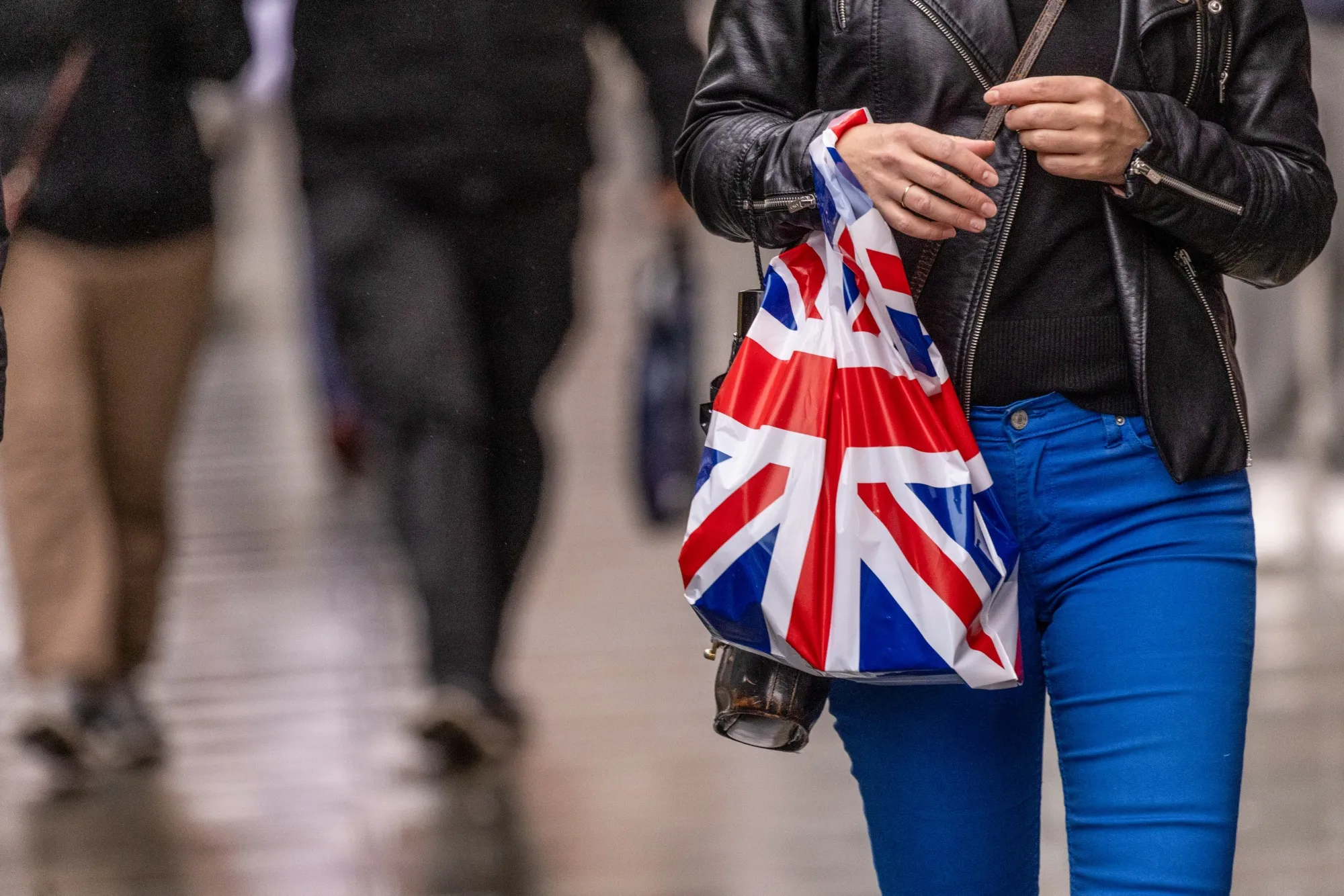 A shopper carries a shopping bag with a British Union flag design along Oxford Street in central London.