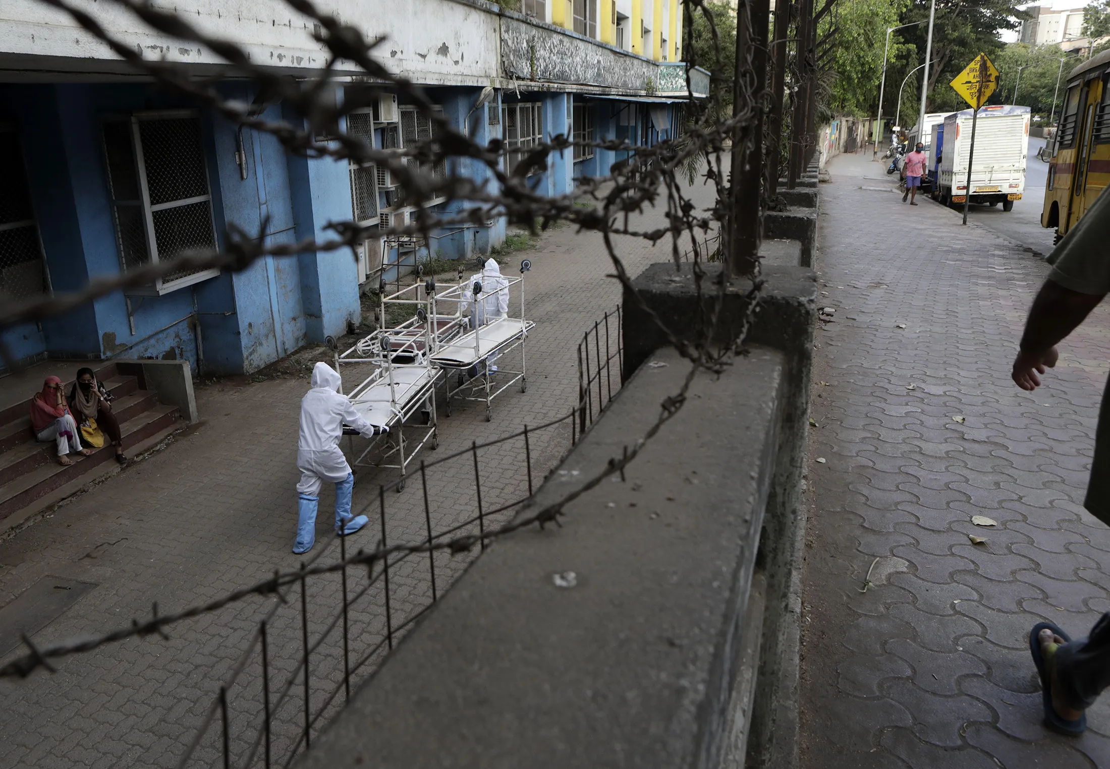 Hospital staff dressed in protective gear carry empty stretchers from a morgue towards a hospital in Mumbai, India, on May 29.