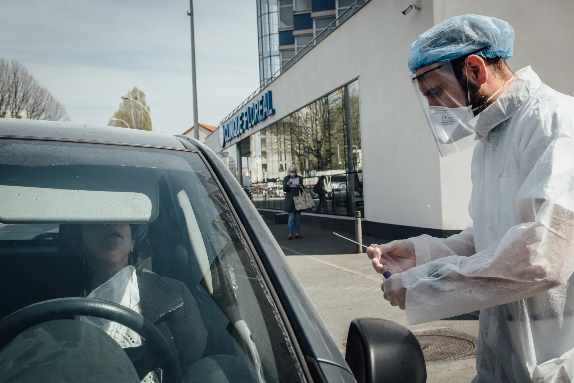 A doctor wearing personal protective equipment (PPE) prepares to swab a healthcare worker at a drive-thru coronavirus testing center in Paris, France, on&nbsp;April 7.