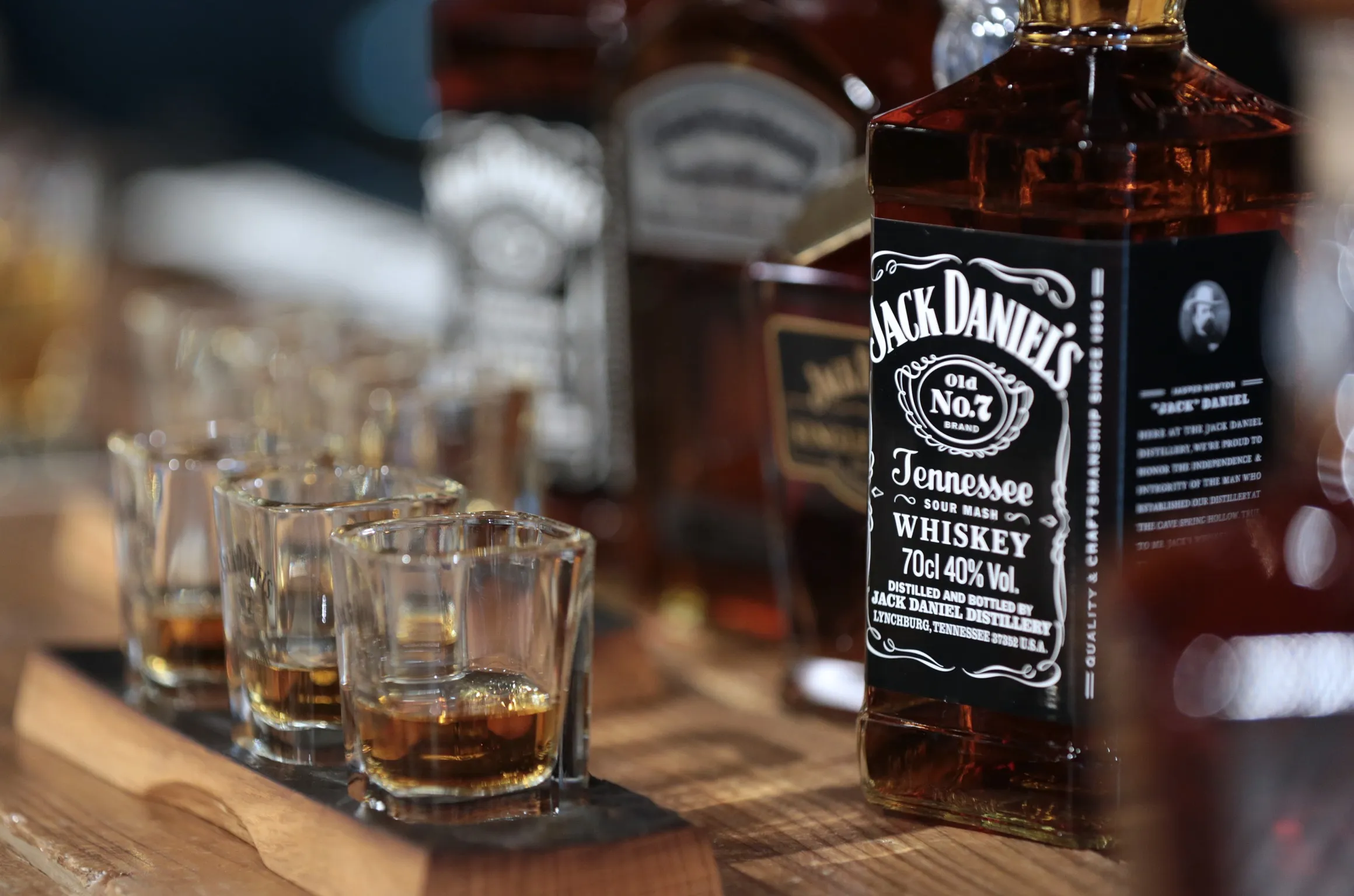 Shot glasses containing various brands of Jack Daniel's whiskey.