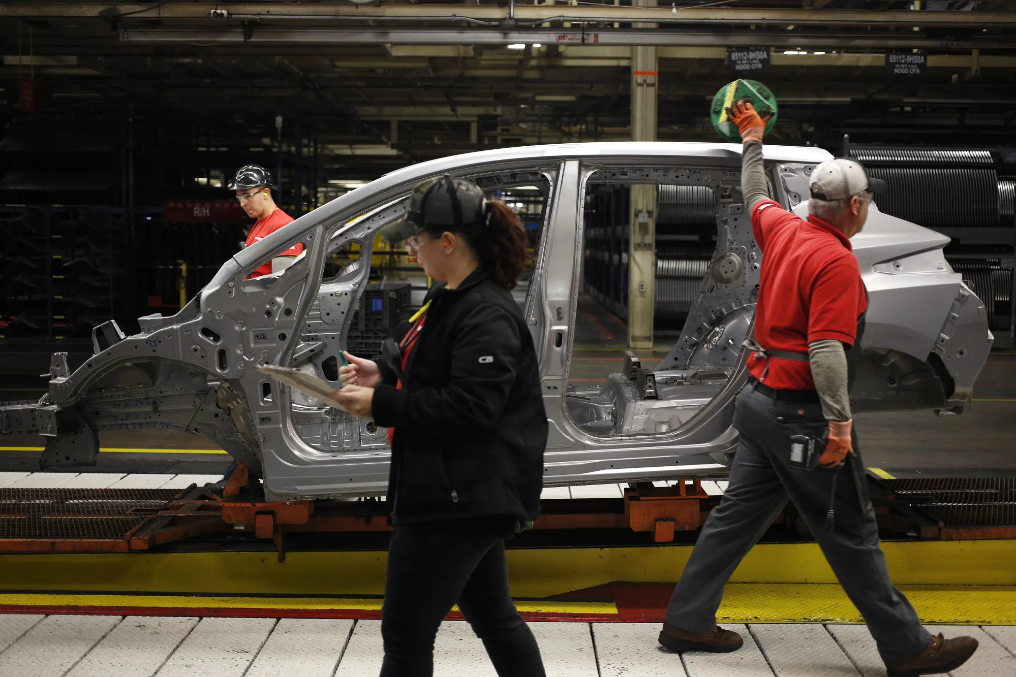 Workers inspect a vehicle frame on the assembly line in Tennessee.