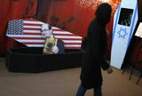 An Iranian woman walks past mock coffins