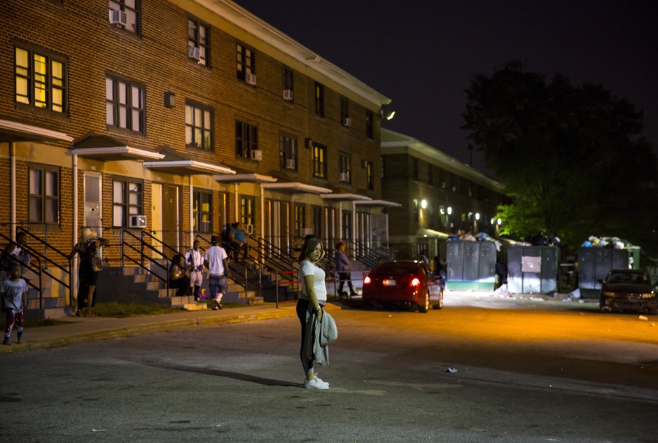 A young woman outside the Gilmor Homes public housing project in Baltimore, MD, in 2015. 