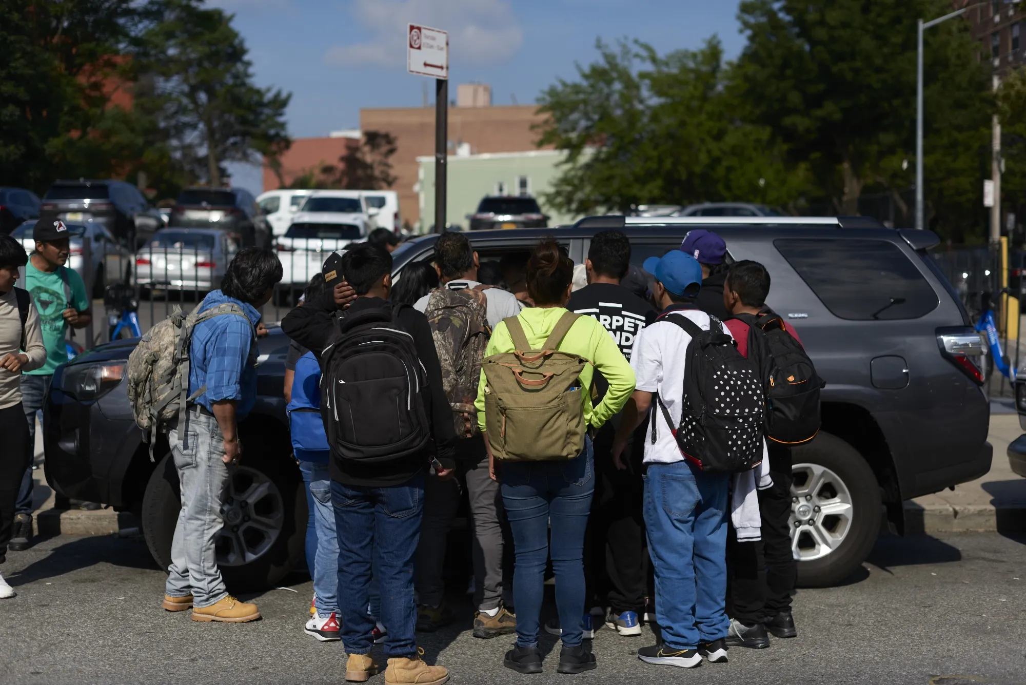 Migrant job seekers approach a vehicle looking for day laborers in the Queens borough of New York, US, on Thursday, June 29, 2023.