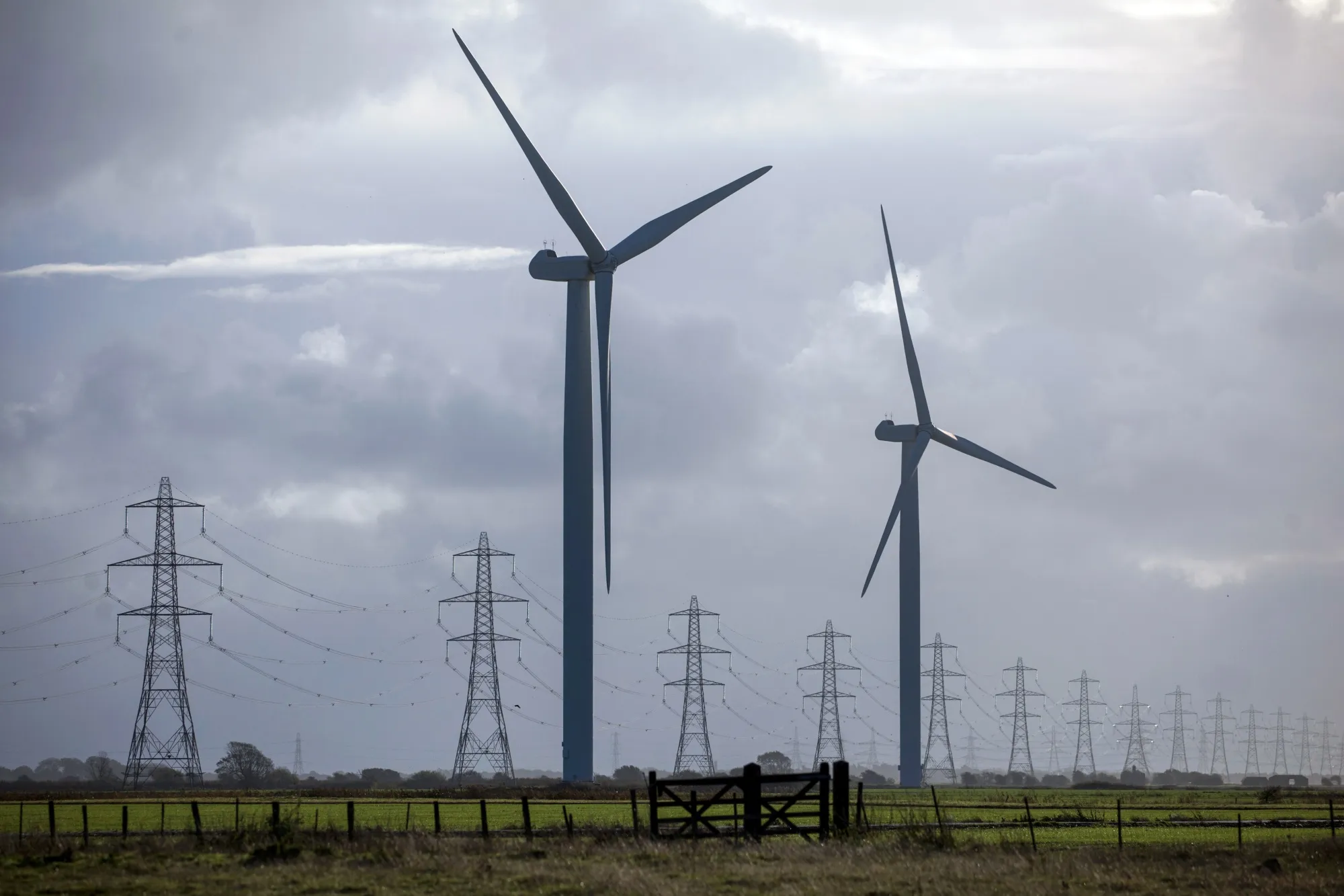 Onshore wind turbines and electricity pylons&nbsp;near Camber, U.K.