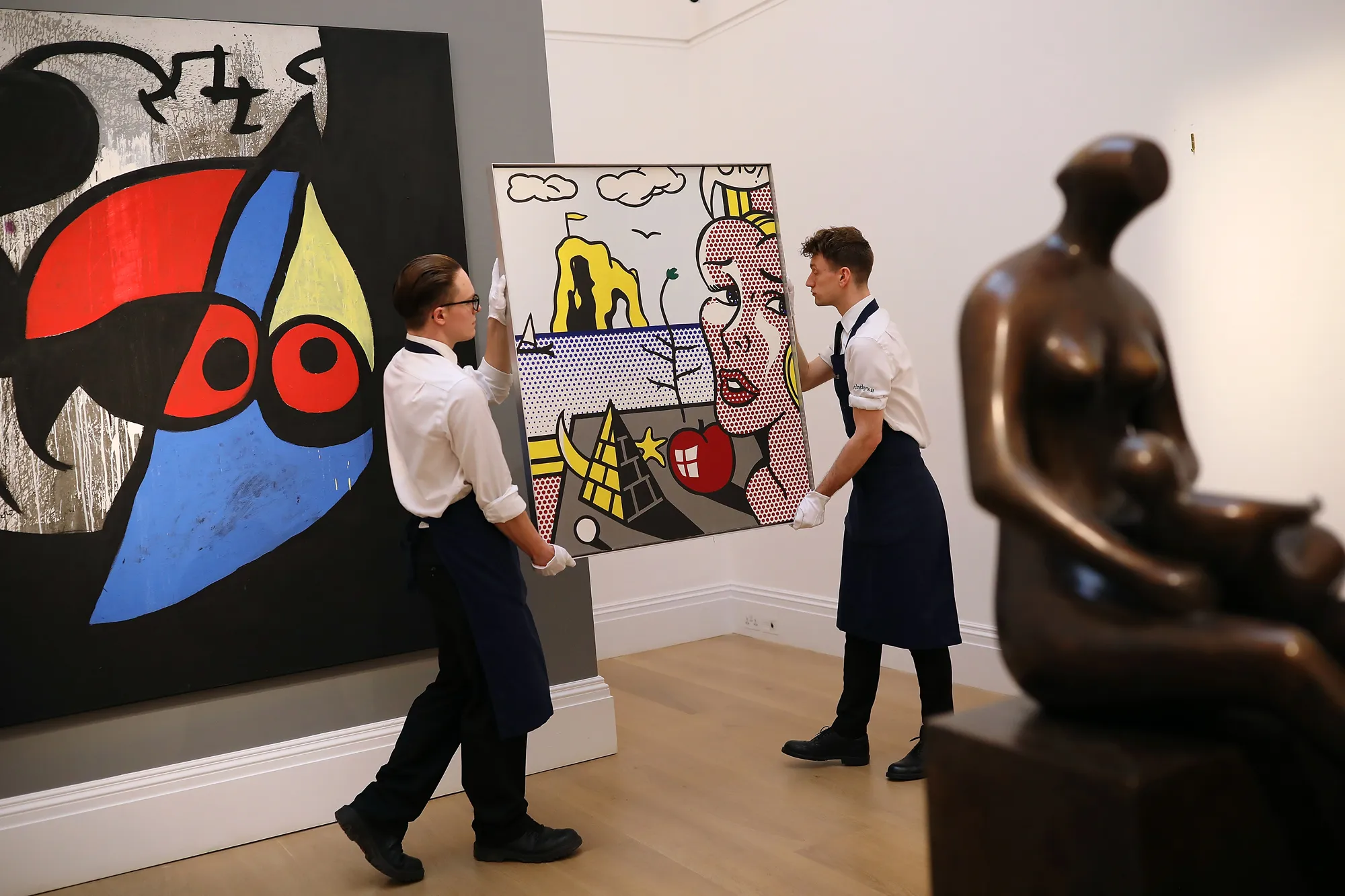 Sotheby's employees pose with a painting during a preview of the 'Impressionist and Modern Art' sale in London, on April 9, 2018.&nbsp;