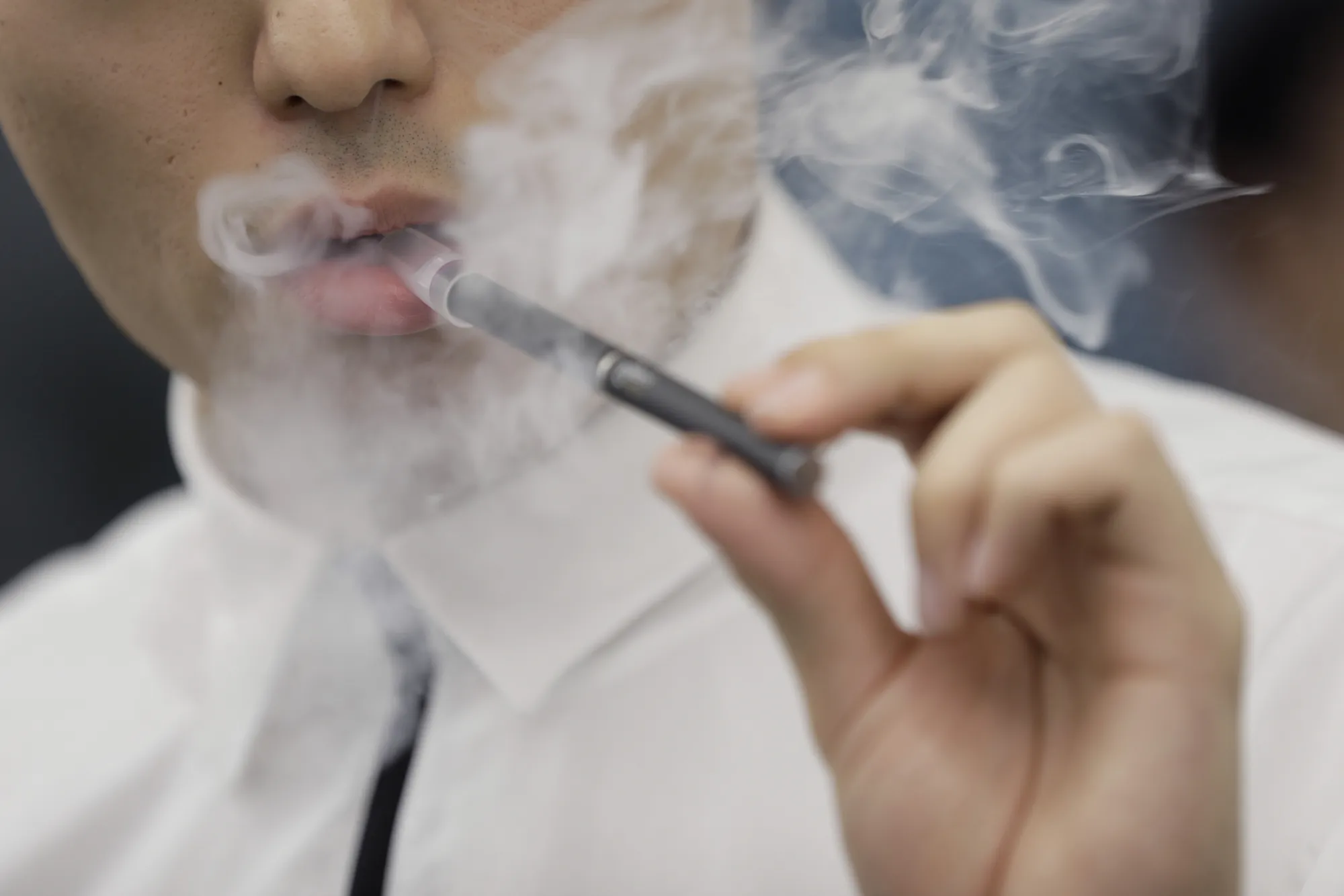 An attendant demonstrates Japan Tobacco Inc.'s Ploom Tech smokeless tobacco device for a photograph during a media preview at the company's Ploom Shop Ginza in Tokyo, Japan, on Wednesday, June 28, 2017. By next week, smokeless devices by Japan Tobacco, British American Tobacco Plc and Philip Morris International Inc. will be sold in Tokyo, vying to dominate the race for next-generation tobacco products.
