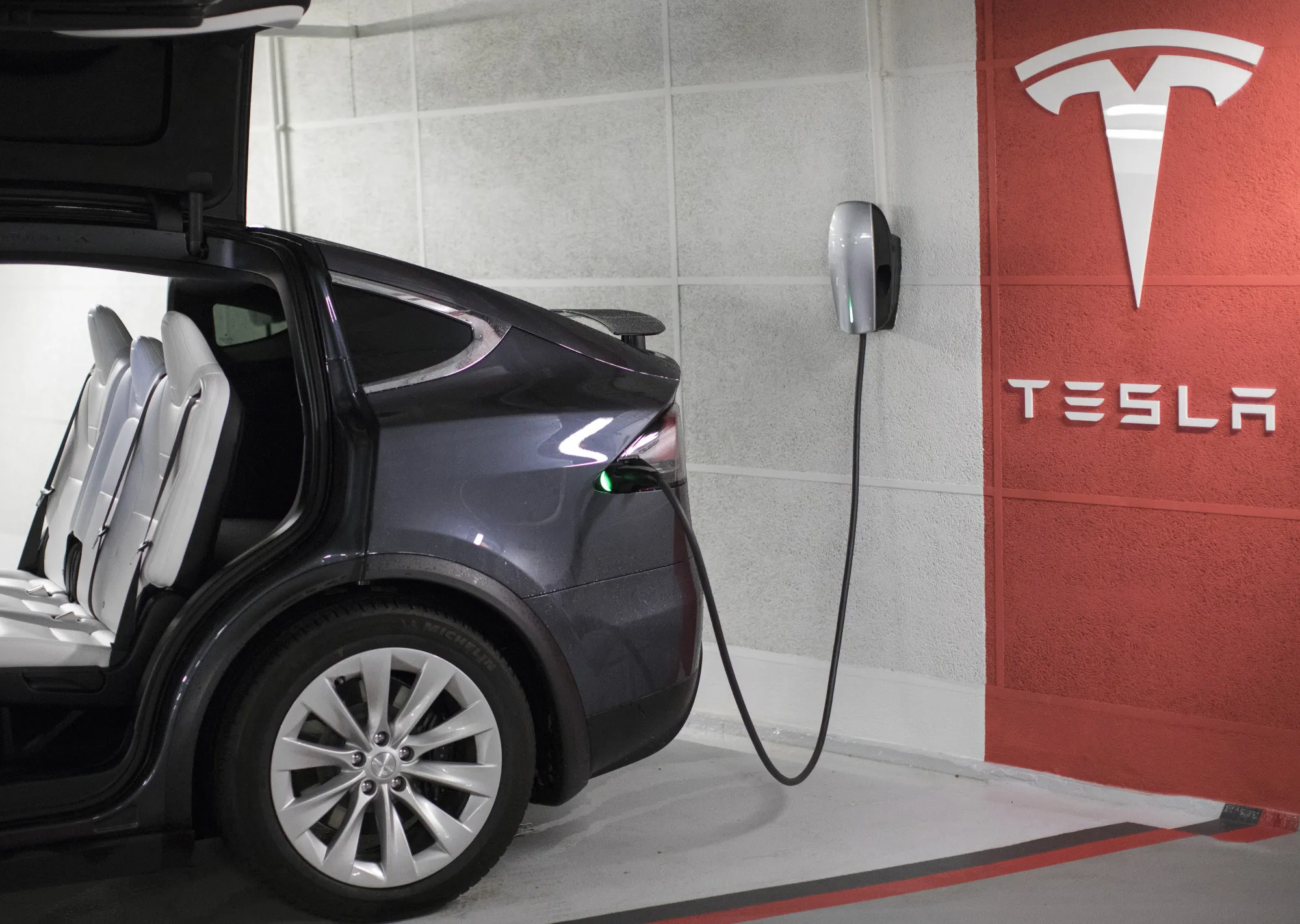 A plug sits connected to a Tesla Inc. Model X electric automobile at a charging point in a parking lot in Frankfurt, Germany, on Friday, Aug. 11, 2017. Germany's government wants carmakers to increase efforts to reach its goal of 1 million electric vehicles on German roads by 2020, Steffen Seibert, Chancellor Angela Merkel’s spokesman, told reporters today in Berlin.