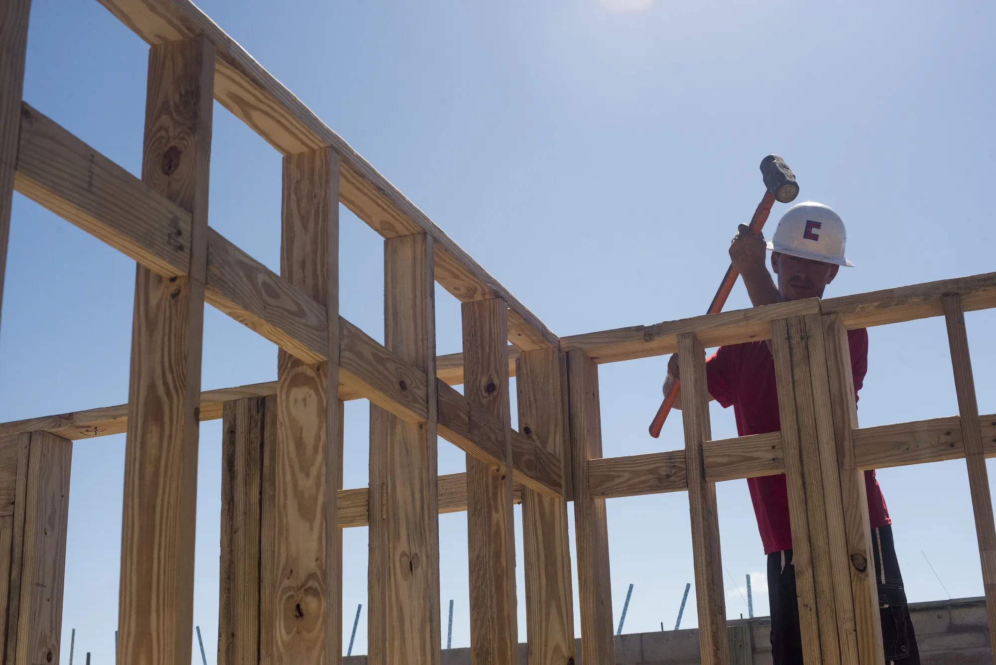 A worker hammers a piece of lumber to a wall frame on a home under construction at the M/I Homes Inc. Bougainvillea Place housing development in Ellenton, Florida, U.S., on Thursday, July 6, 2017.