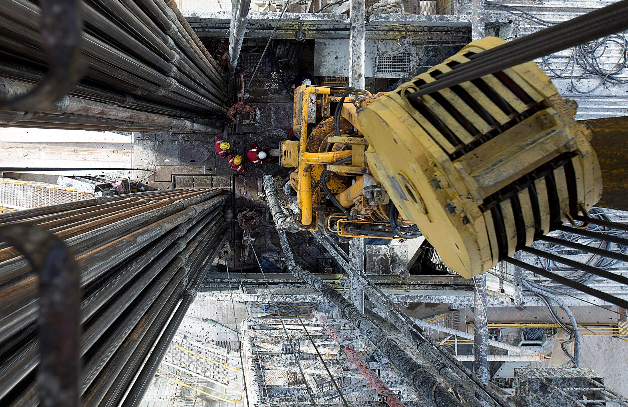 Oil workers operate drill sections while working on the drilling floor beneath the travelling block, right, on a derrick operated by Salym Petroleum in Salym, Khanty-Mansi autonomous region, Russia, on Tuesday, July 2, 2013. Gazprom Neft and Shell have begun exploring for tight oil in Siberia within their Salym Petroleum Development project, while state-run competitor OAO Rosneft has brought in Exxon Mobil Corp., Statoil ASA and Eni SpA to develop shale and offshore projects.
