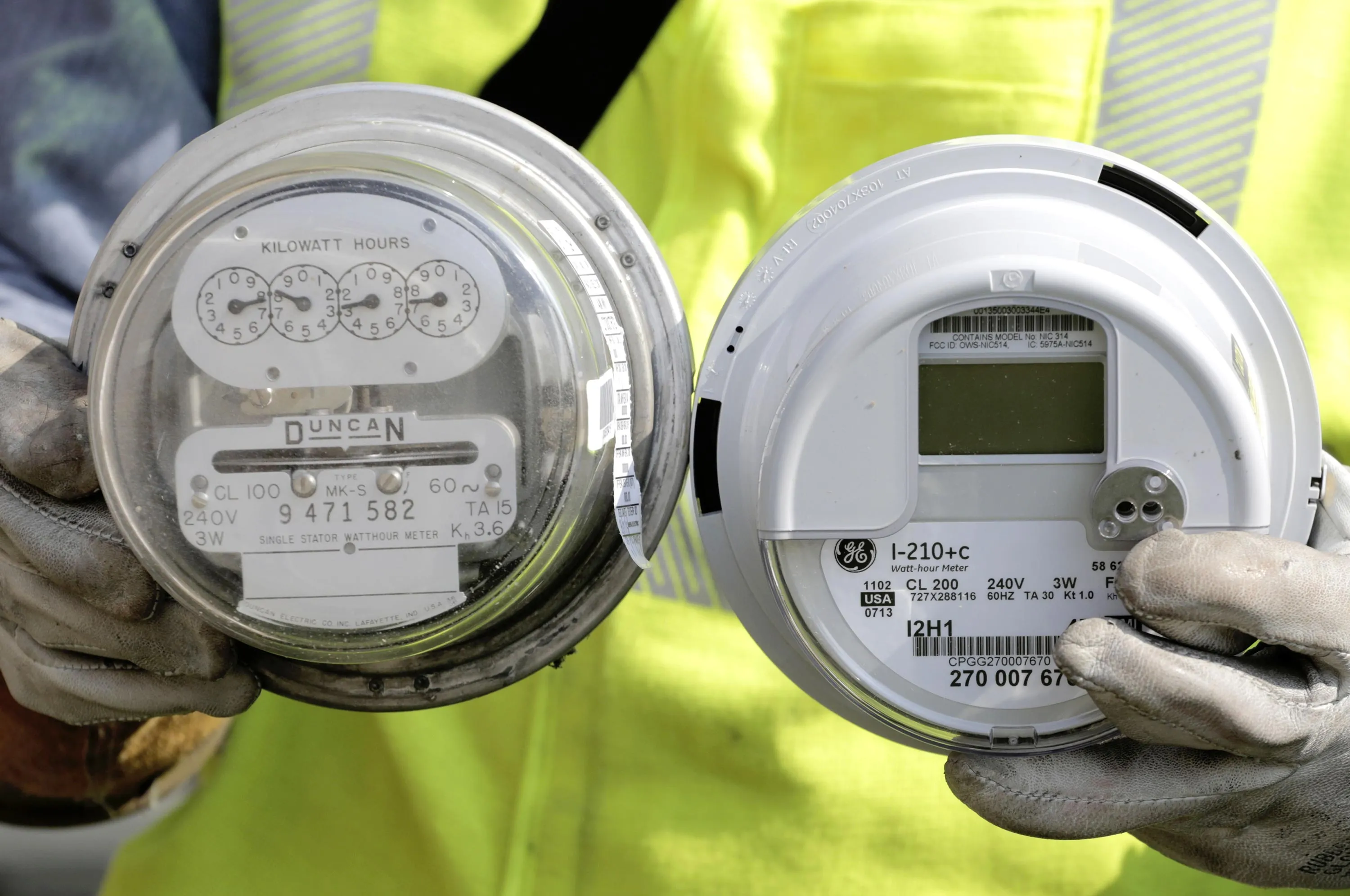 A senior energy technician for Commonwealth Edison holds a standard electricity meter, left, and a new "smart" meter in North Riverside, Ill. on Sept. 6, 2013. Photographer: M. Spencer Green/AP Photo