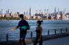 Pedestrians wearing protective masks walk along the water in Brooklyn, on Sept. 4. 