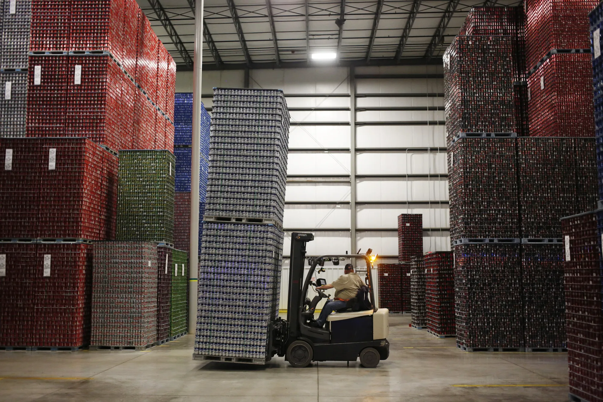 An employee moves pallets of cans inside a warehouse in Findlay, Ohio.