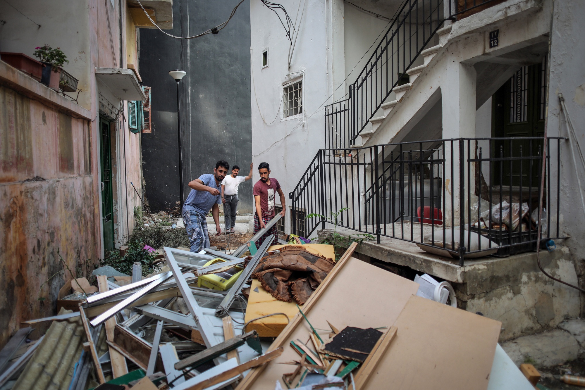 Residents clear broken furniture and debris from a residential building&nbsp;in Beirut, Lebanon, on Aug. 12.&nbsp;
