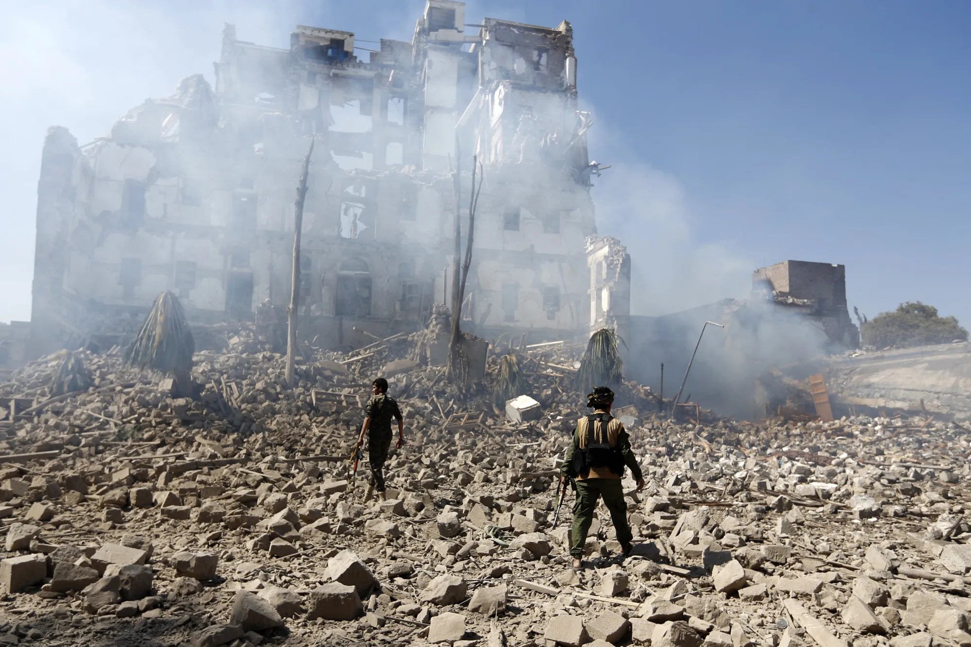 Houthi&nbsp;fighters inspect damage following a reported airstrike carried out by the Saudi-led coalition targeted the presidential palace in the Yemeni capital Sanaa on Dec.&nbsp;5.