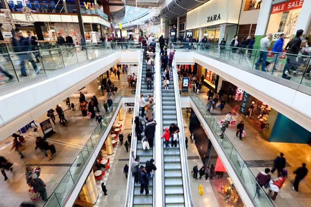 Shoppers pass clothing stores and outlets inside the Westfield Stratford City shopping mall in London on Dec. 27, 2012