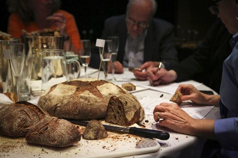 André Soltner (background) judges one of the 15 finalists during the "Best Baguette in NYC" competition.