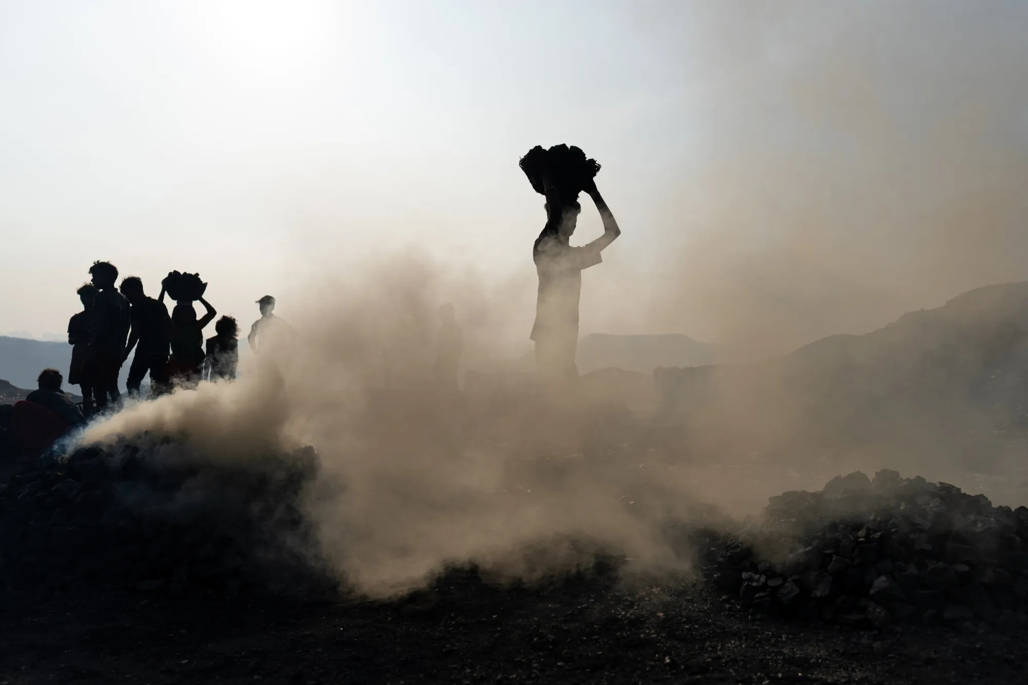 Workers carry coal on their heads at a mine in the outskirts of the city of Dhanbad, in Jharkhand.