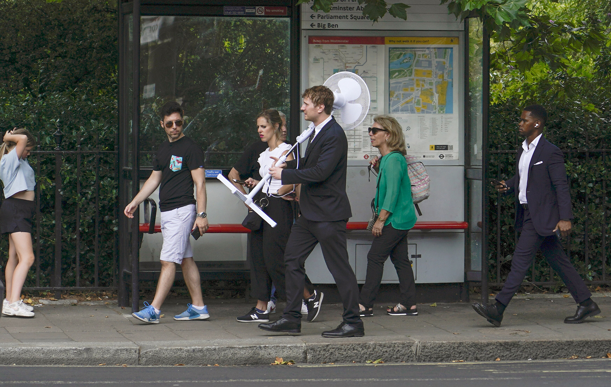 A man carries a fan as he walks through&nbsp;London, on&nbsp;July 12.&nbsp;