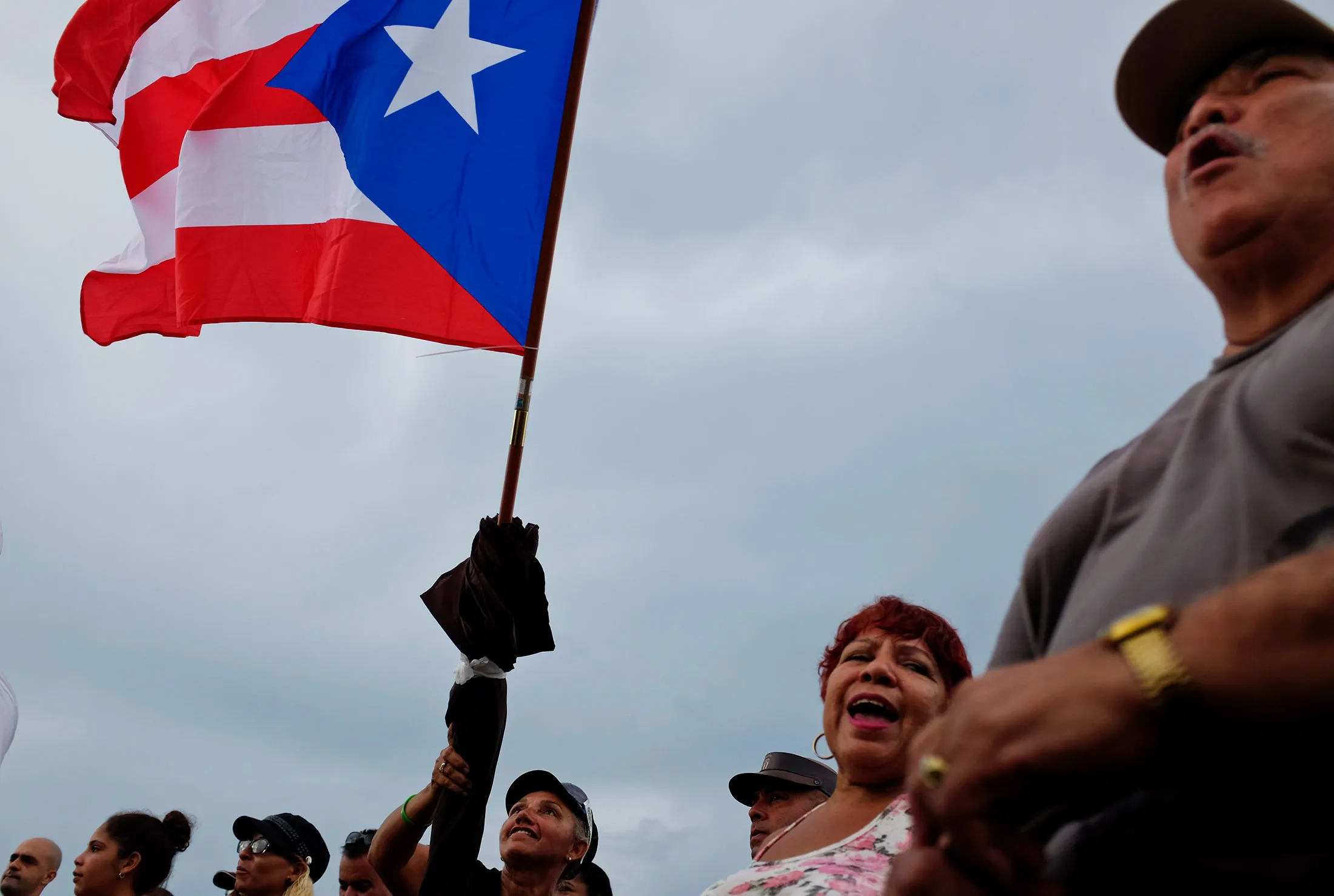 Teresa Otero flies a Puerto Rican flag during an outdoor festival for a Latin radio station’s anniversary in Kissimmee, Fla., on Aug. 16, 2015. 
