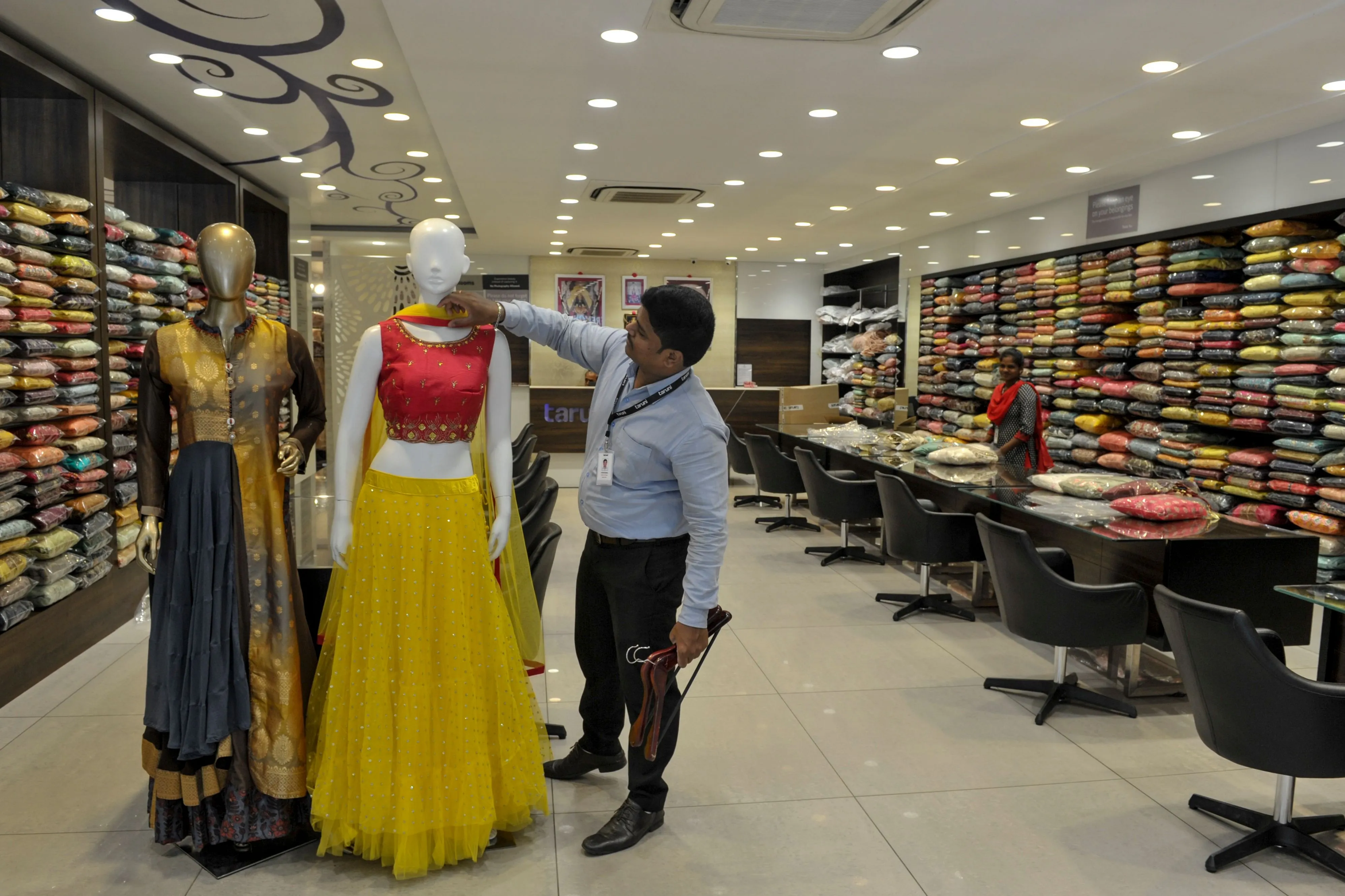 A staff arranges outfit on a mannequin at a shop in Hyderabad on Sept. 28.