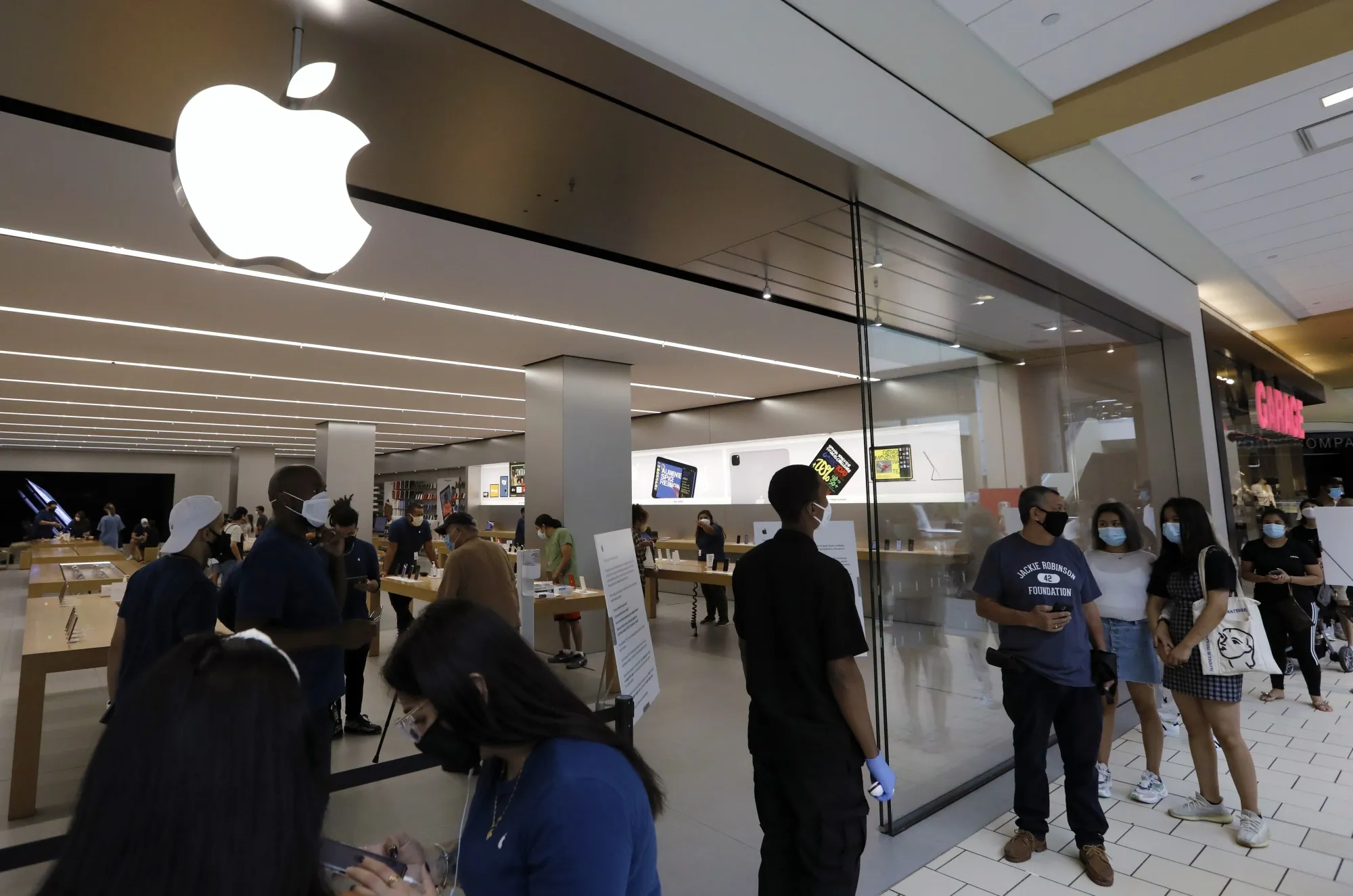 Shoppers stand in line to enter the Apple store at the Queens Center shopping mall in&nbsp;Queens,&nbsp;New York.