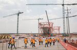 Workers pass in front of a terminal under construction at the New International Airport of Mexico City (NAICM) in Texcoco, Mexico, on&nbsp;April 13, 2018.&nbsp;